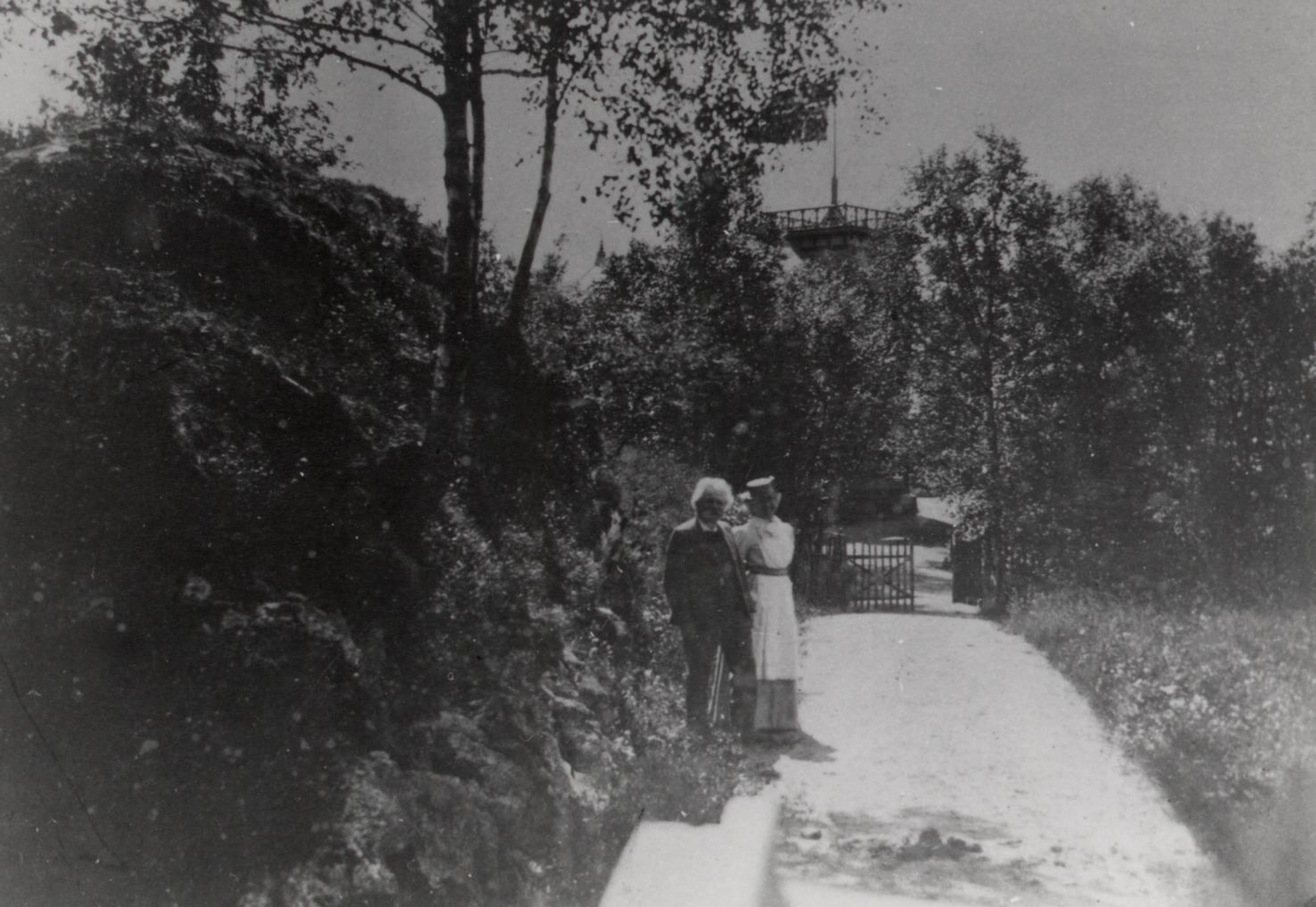 Edvard og Nina Grieg i et sorthvitt foto der de står utenfor Troldhaugen