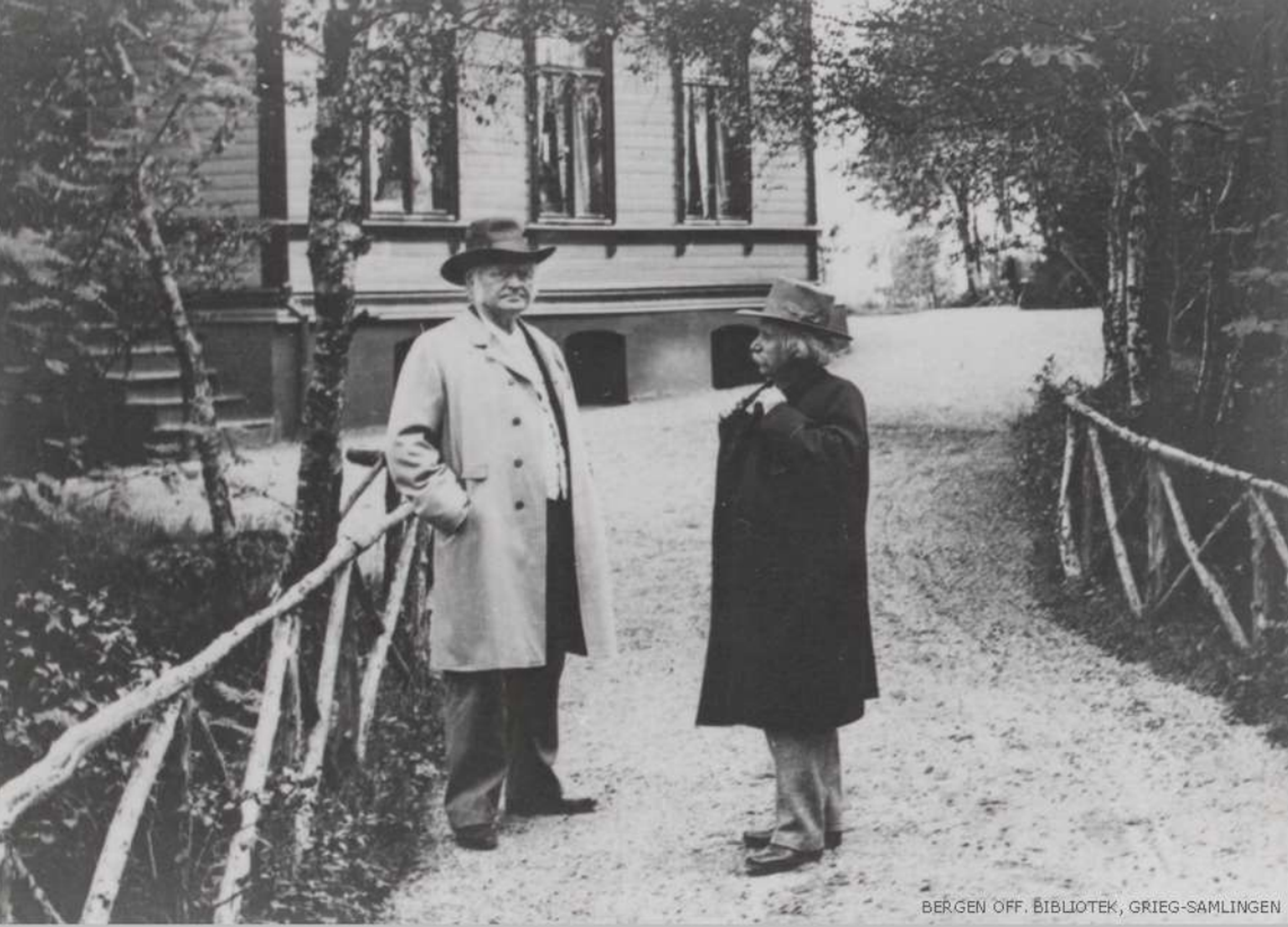 Bjørnstjerne Bjørnson og Edvard Grieg står sammen utenfor villaen