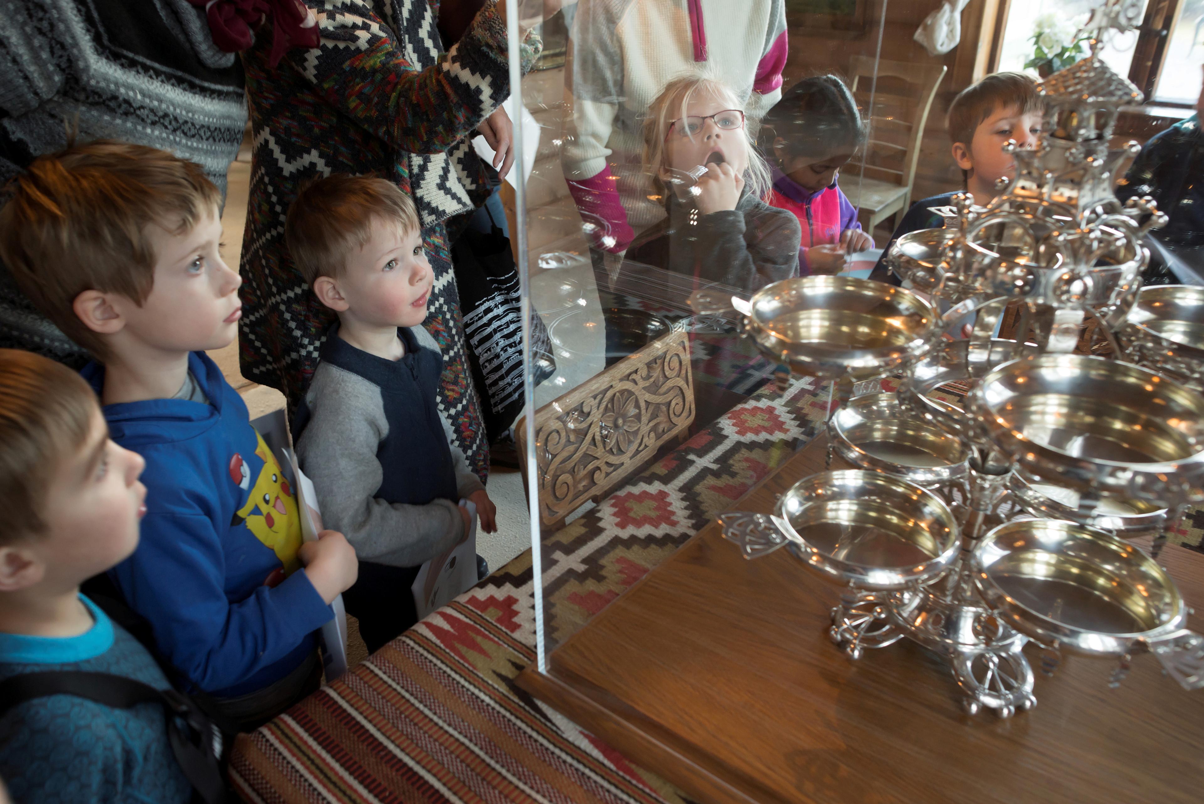 Foto av en gruppe barn i villaen på Troldhaugen, som ser på en stor oppsats av sølv.