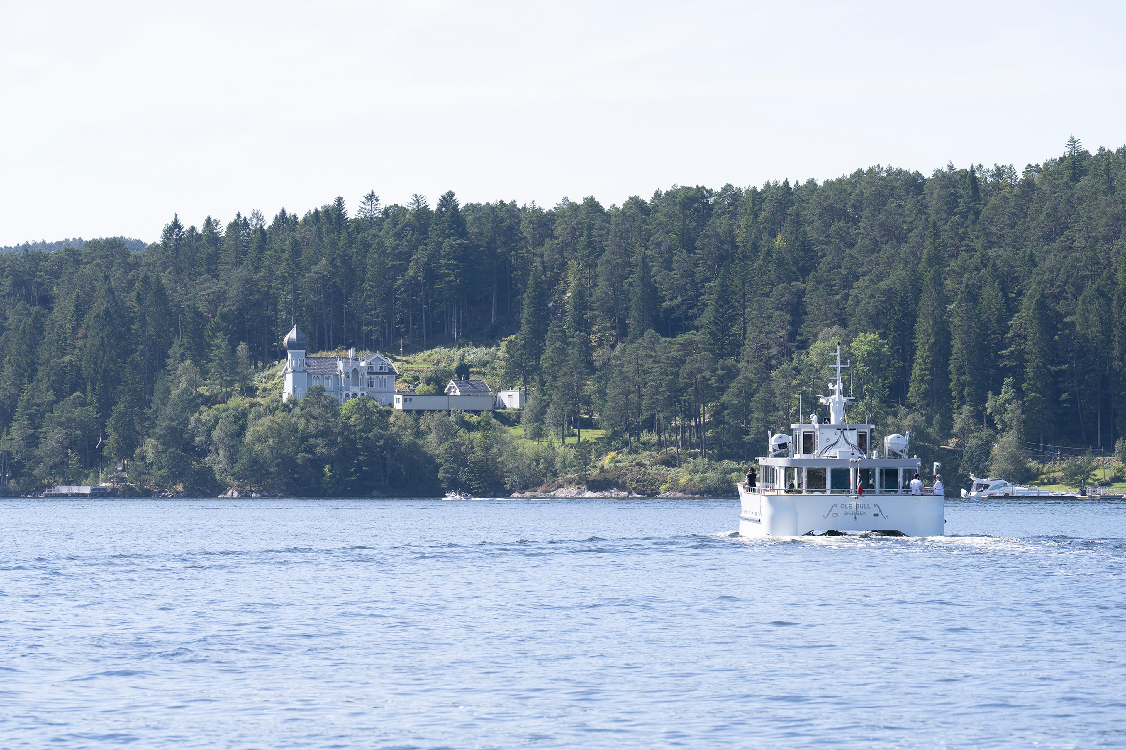Foto av Kodes museumsbåte på vei inn mot Lysøen over fjorden.