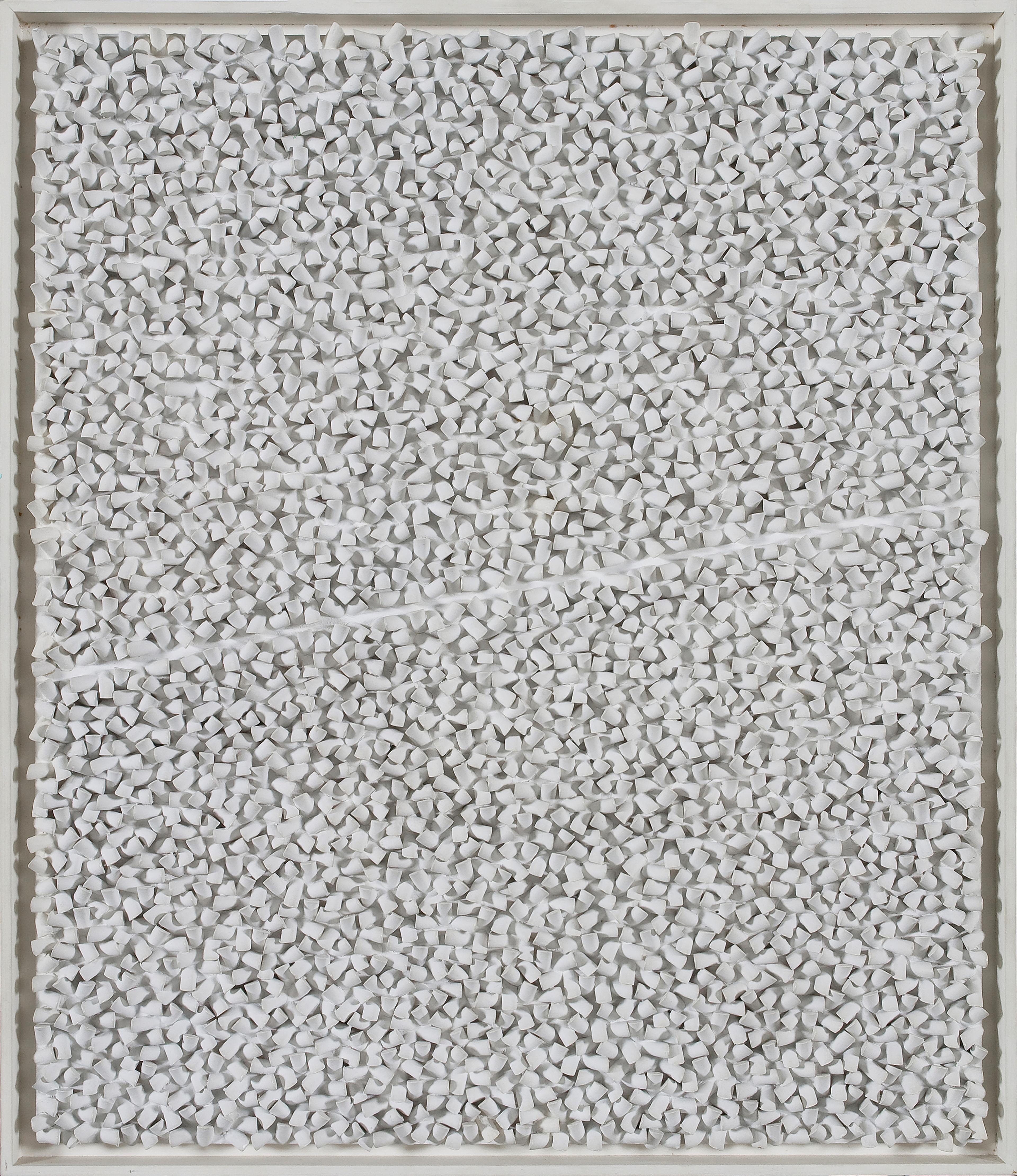 Et bilde som viser et relieff med små knotter i tre, malt i hvitt