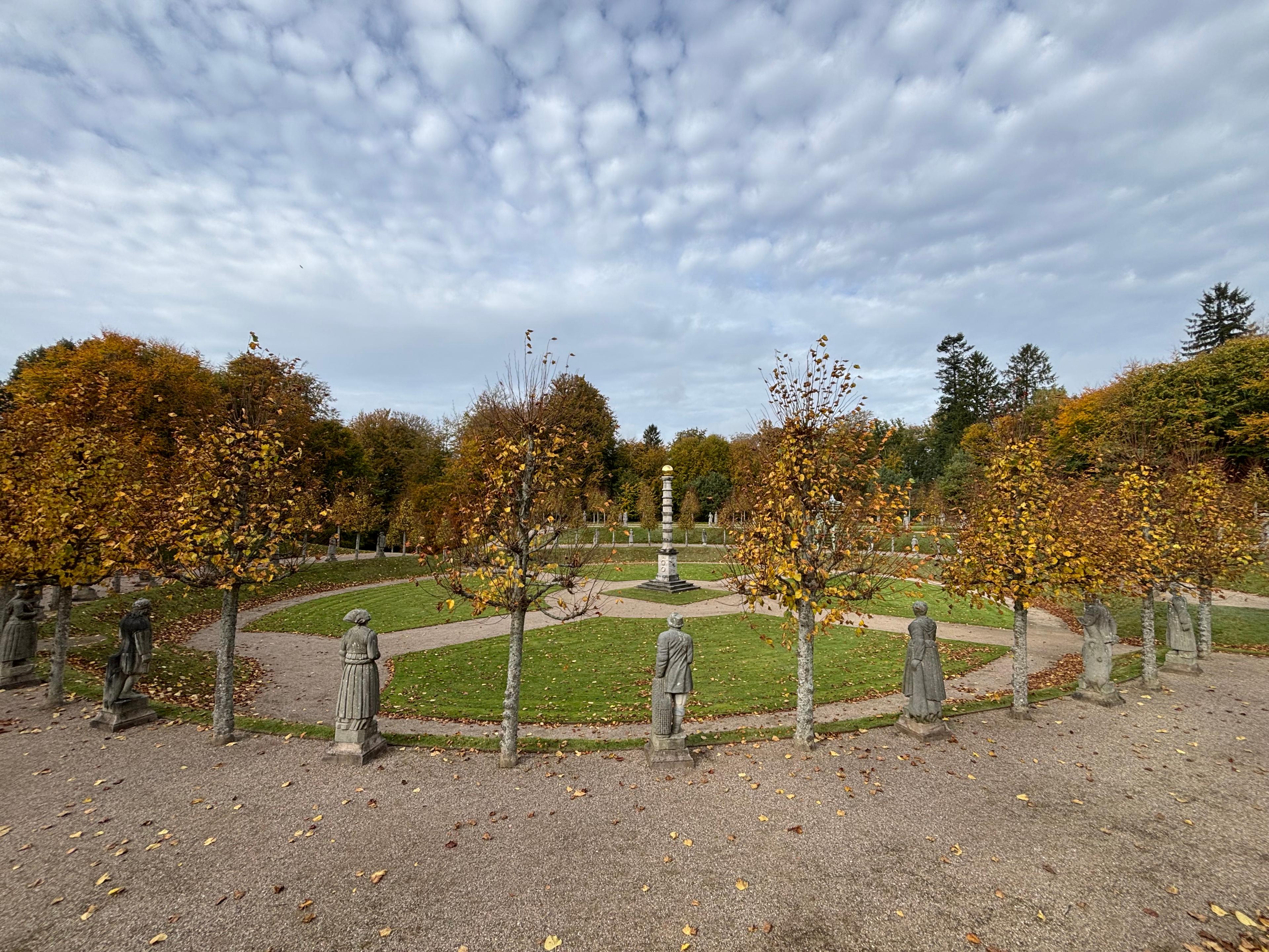 Fra en utendørs skulpturpark, med statuer i stein av ulike mennesker. 