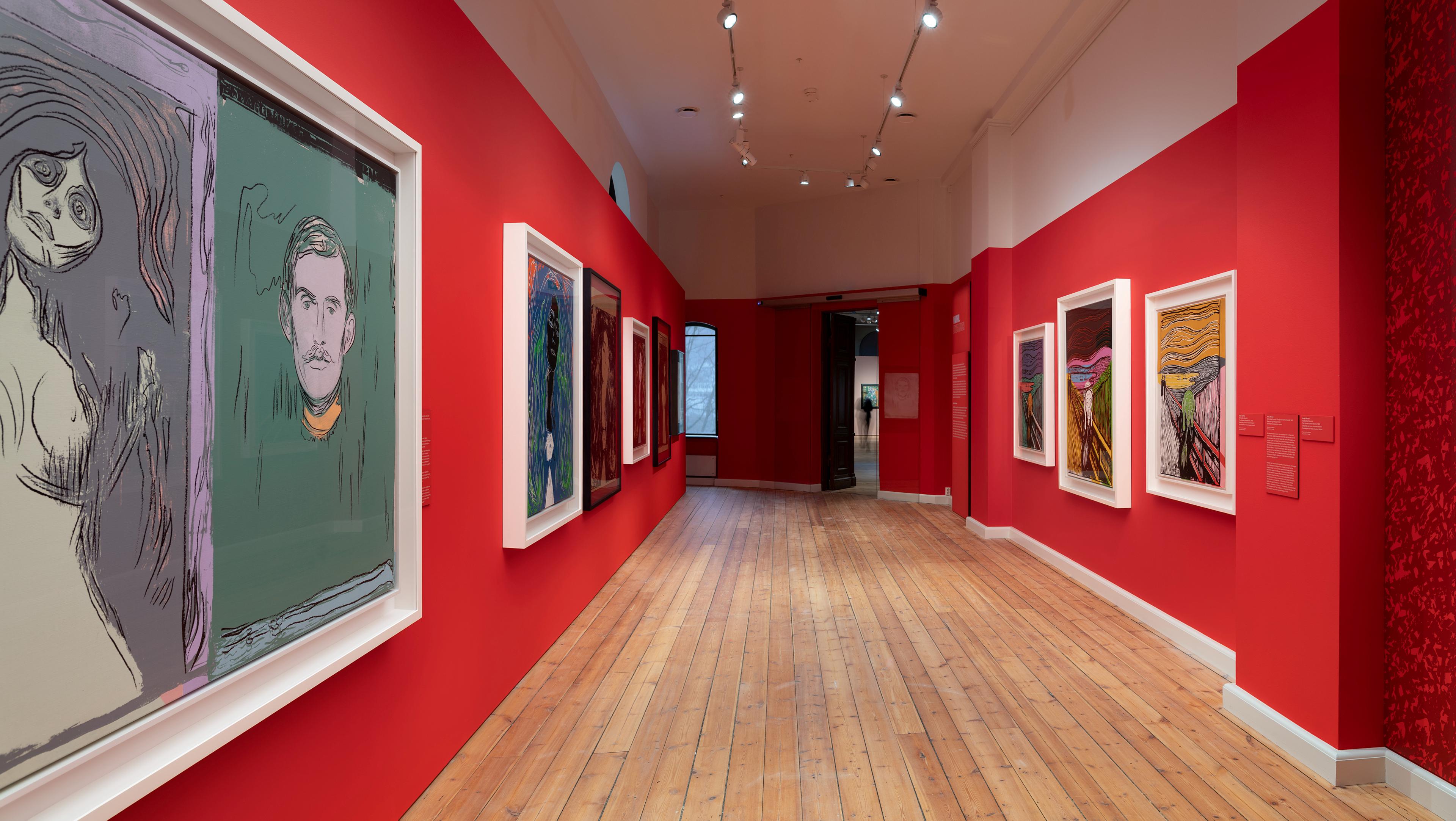 En rekke malerier av Andy Warhol i utstillingen brikker, i et rom med røde vegger
