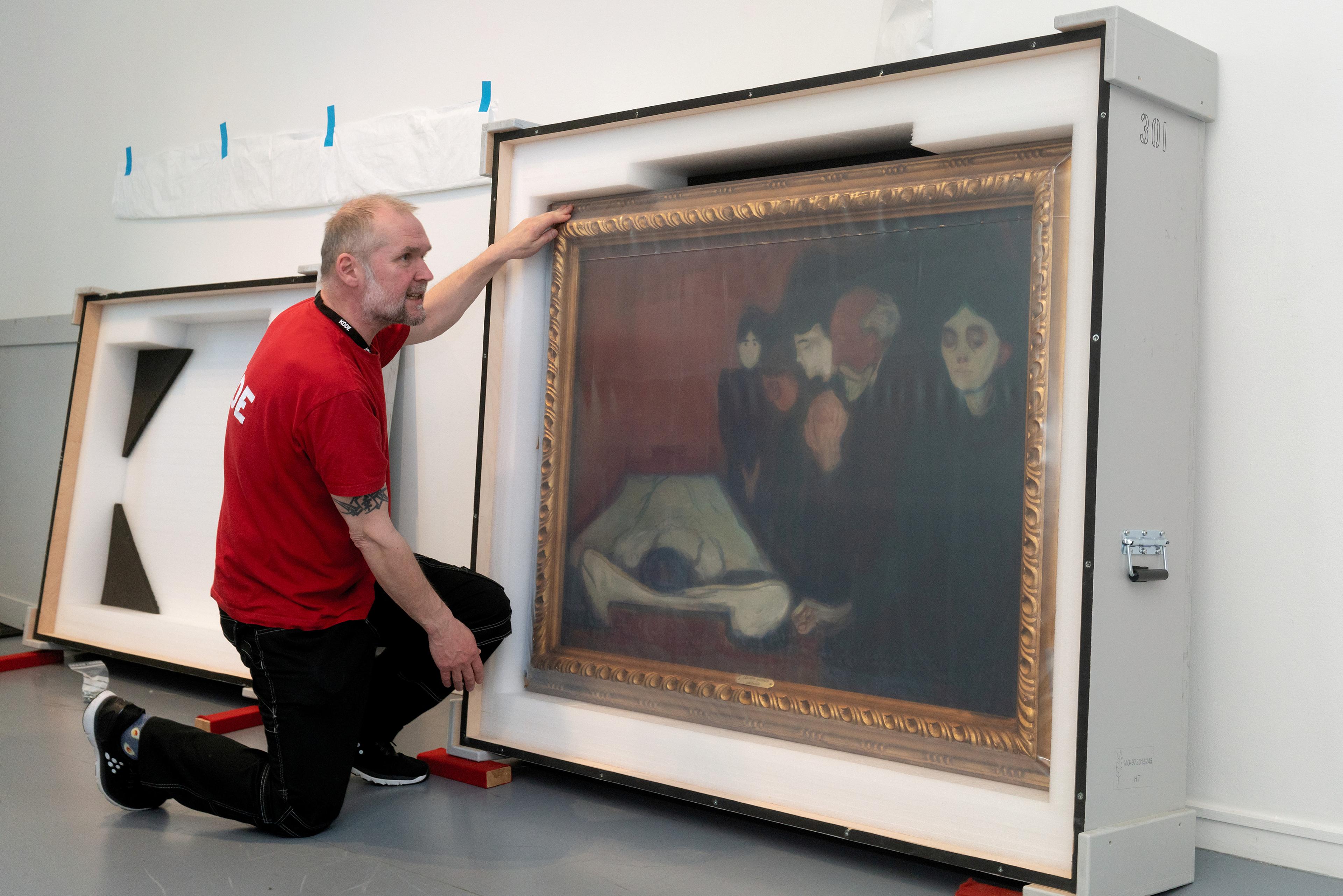 A museum technician preparing a painting by Edvard Munch for transport.