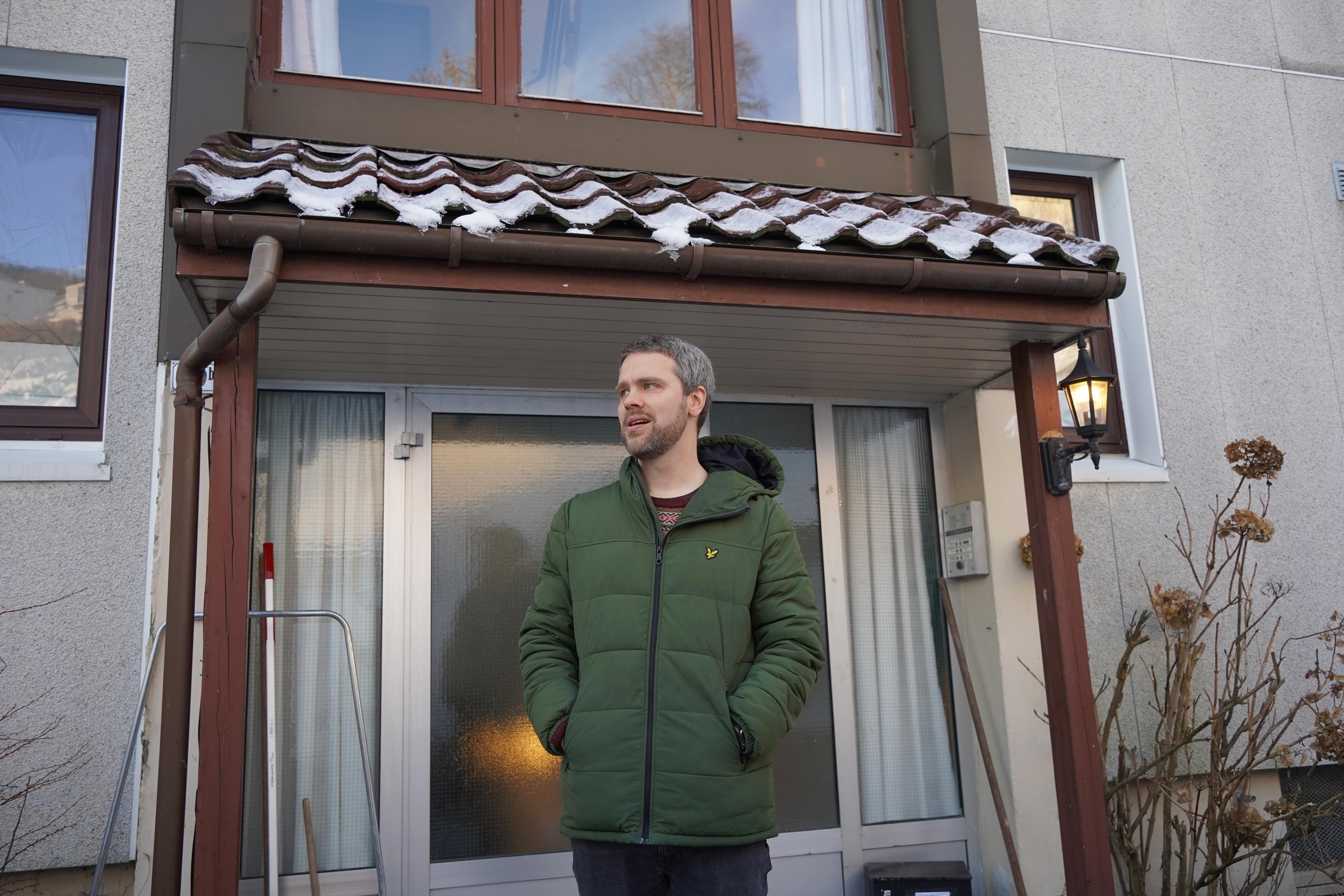 Komponisten Ørjan Matre står foran en inngangsdør. Han er kledd i en grønn ytterjakke.