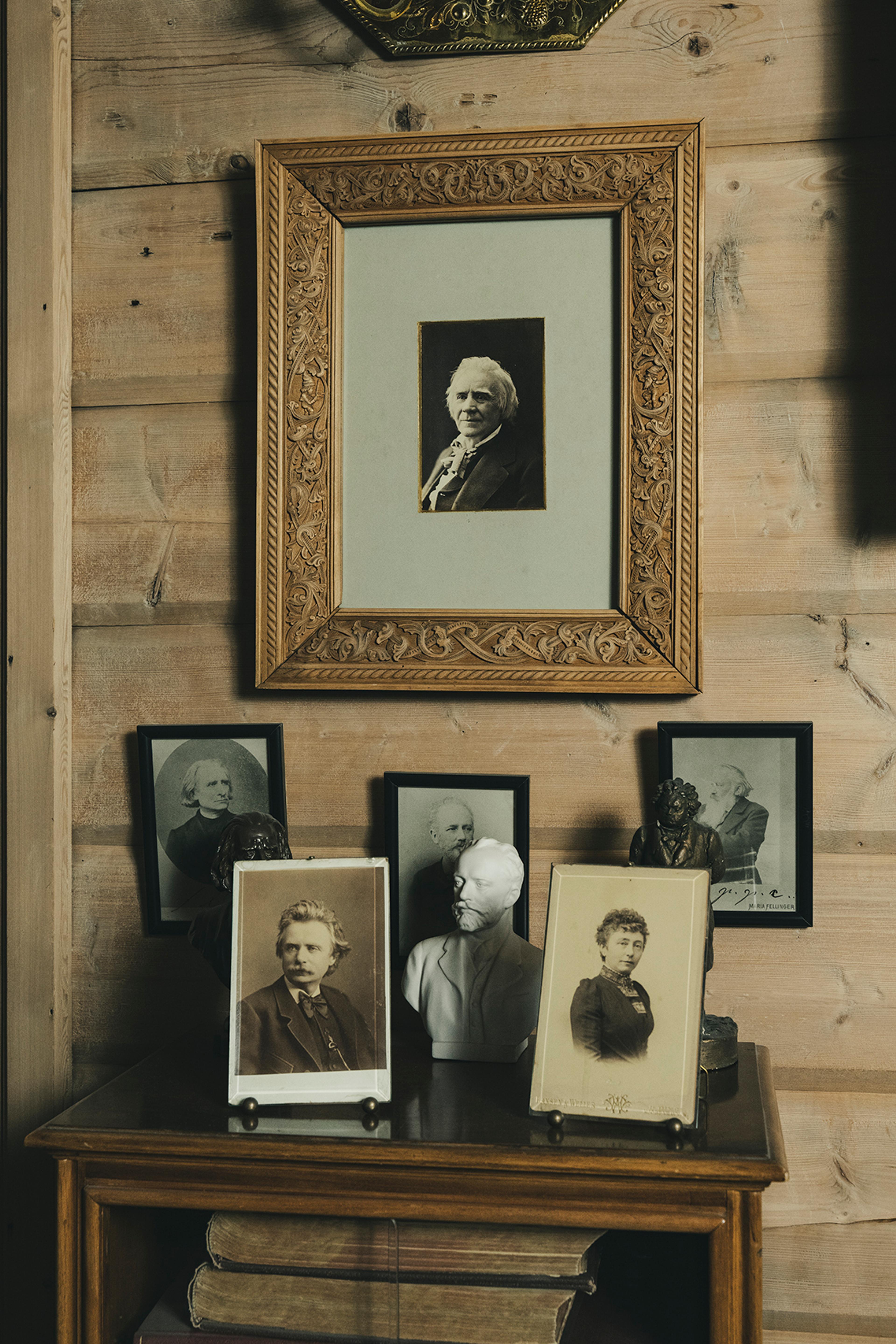 Flere fotografier og bilder i Griegs villa, plassert oppå et bord. Et av bildene viser Ole Bull.