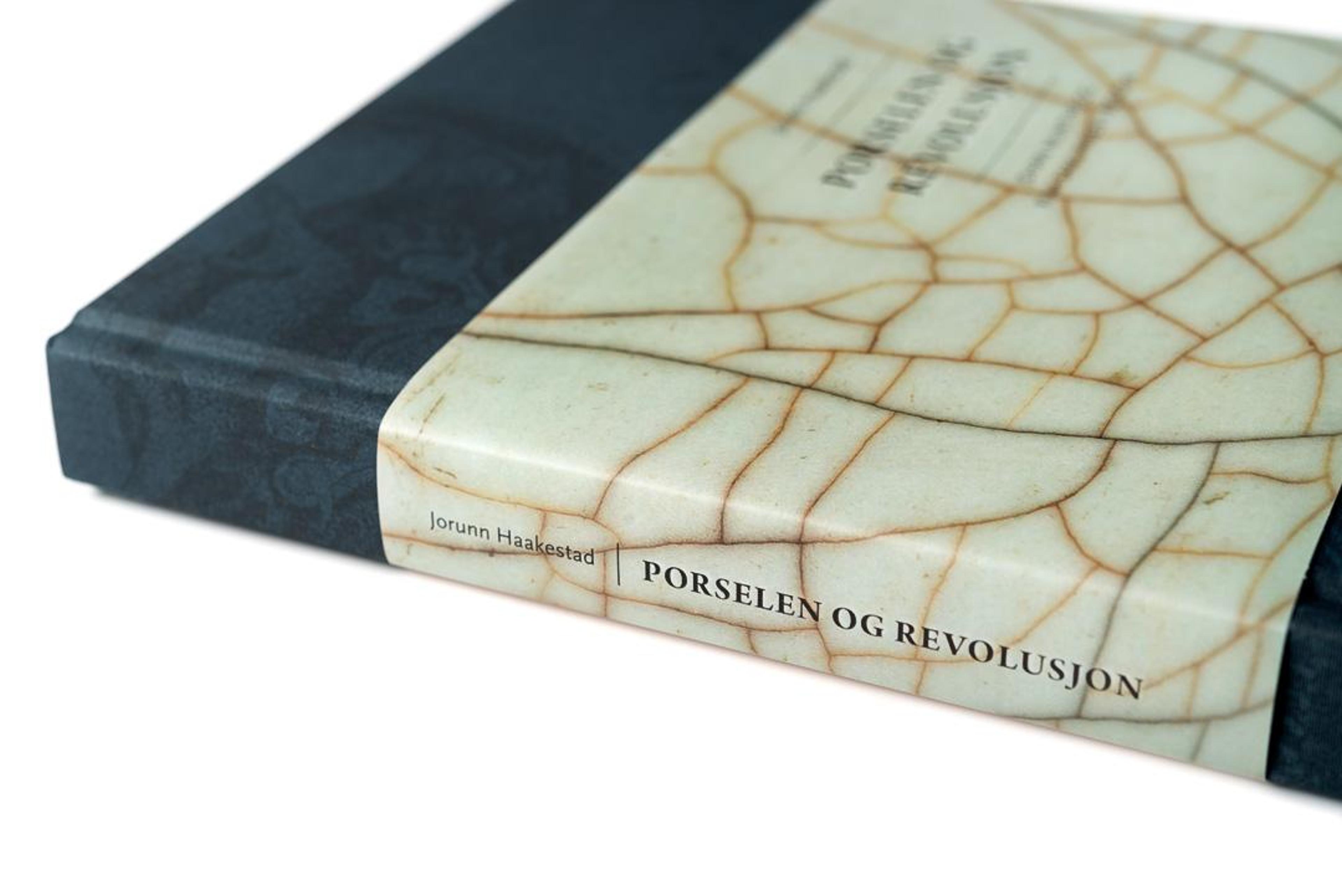 Foto av en bok med tittel «Porselen og revolusjon»