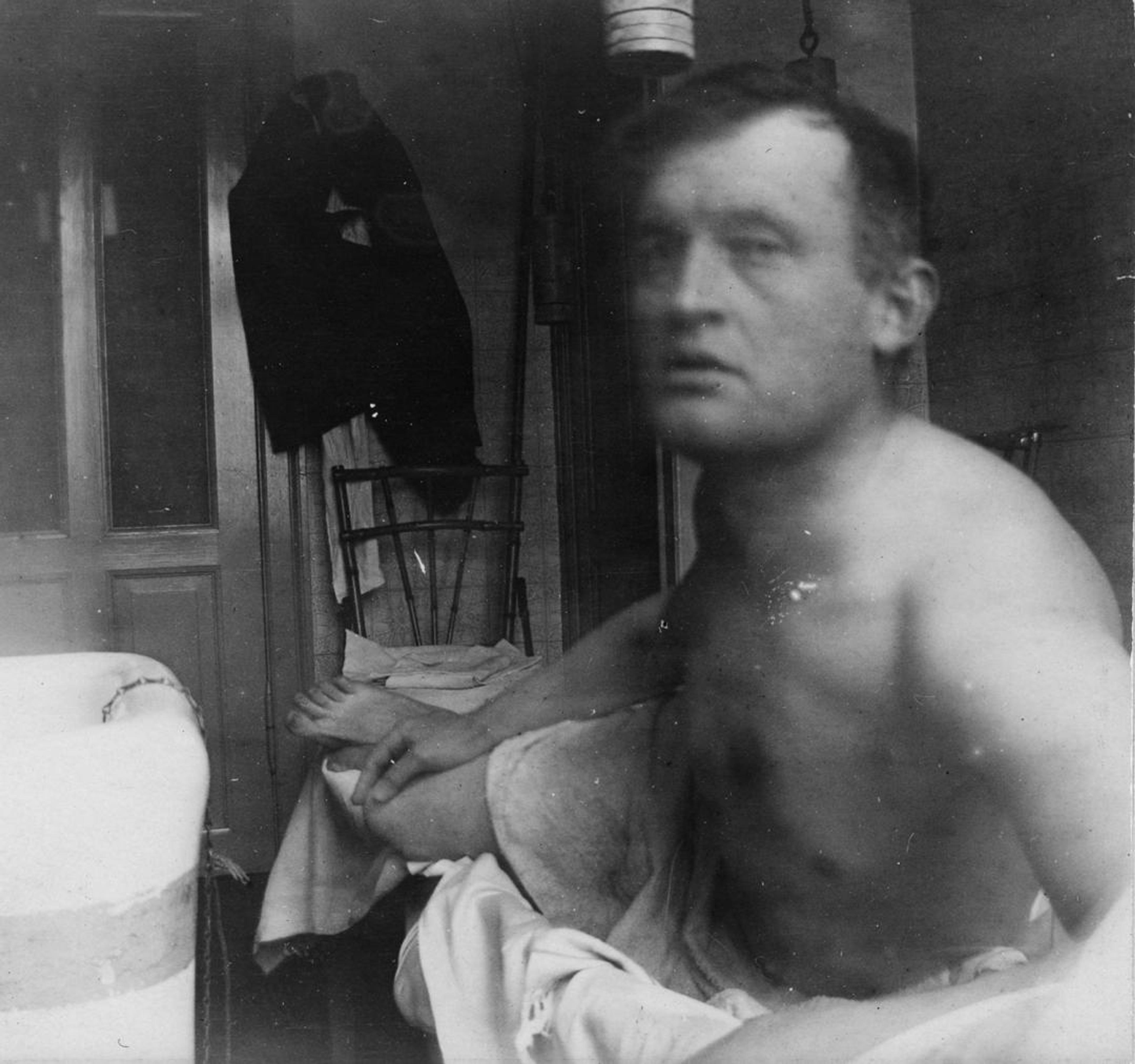 Et fotografisk selvportrett av Edvard Munch liggende i helfigur, kun ikledt et laken.