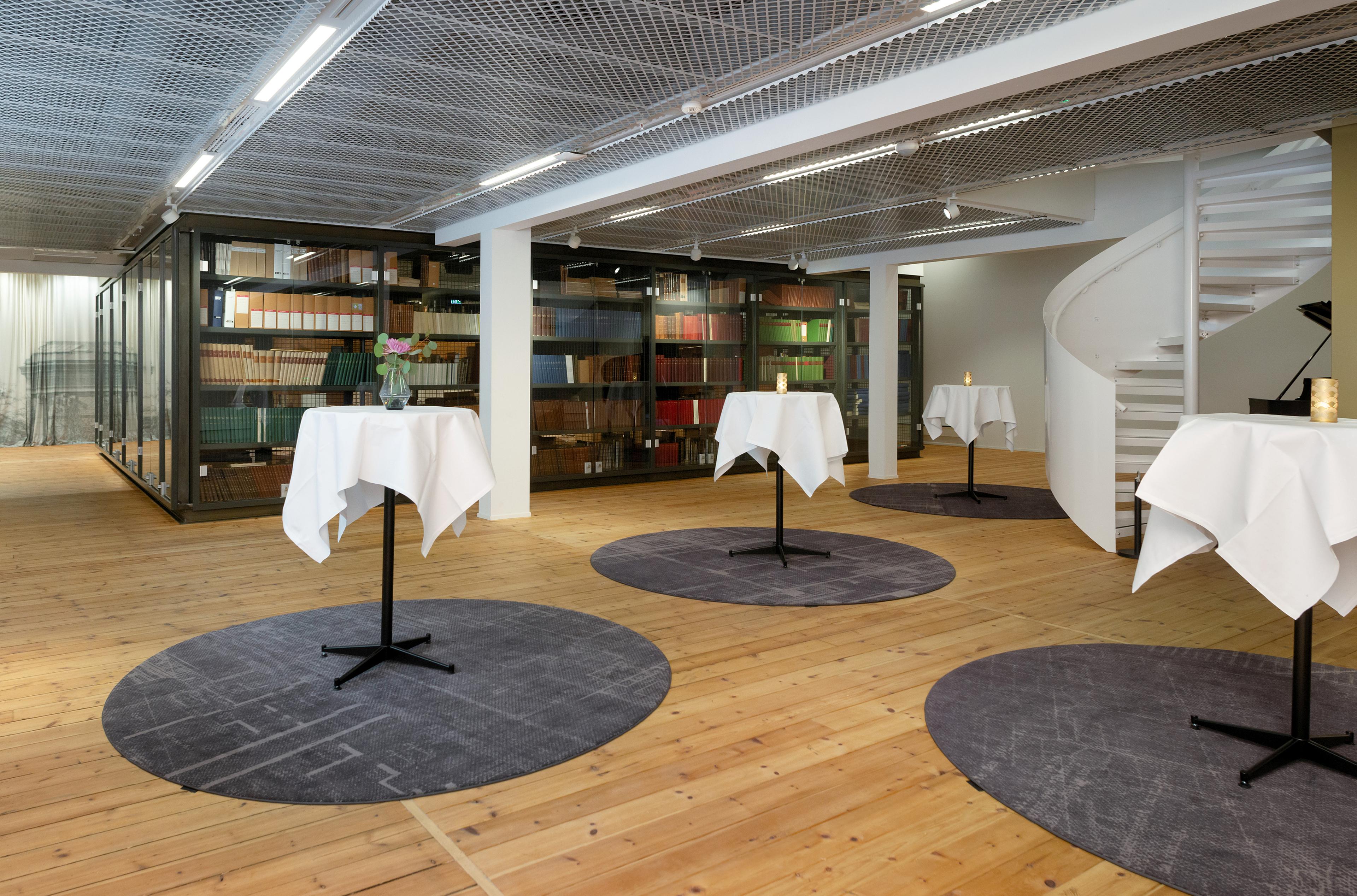 Biblioteket i Permanenten, med høye bord dekket med hvite duker.