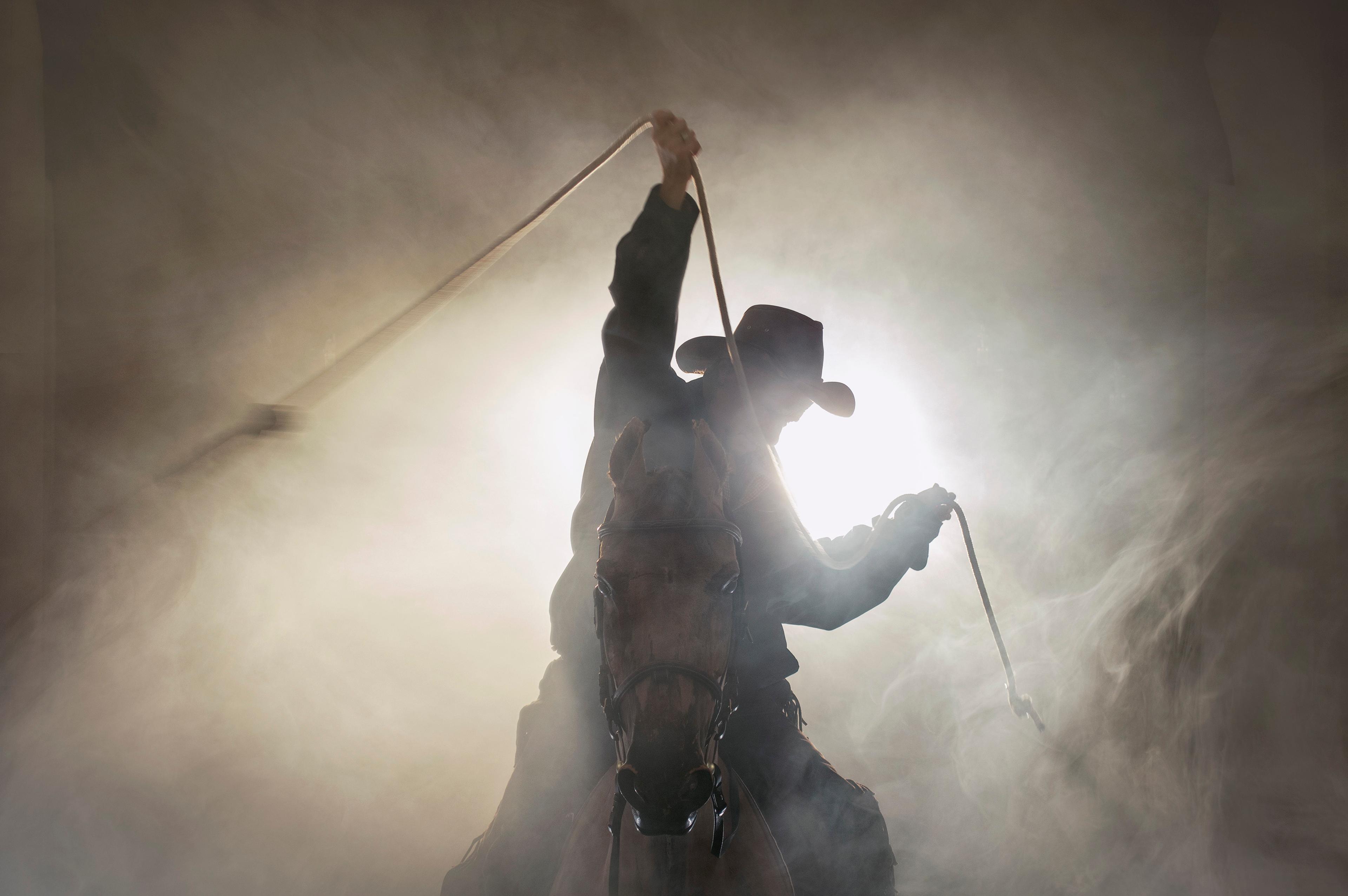 fotokunst som viser en cowboy til hest i et røykfylt landskap