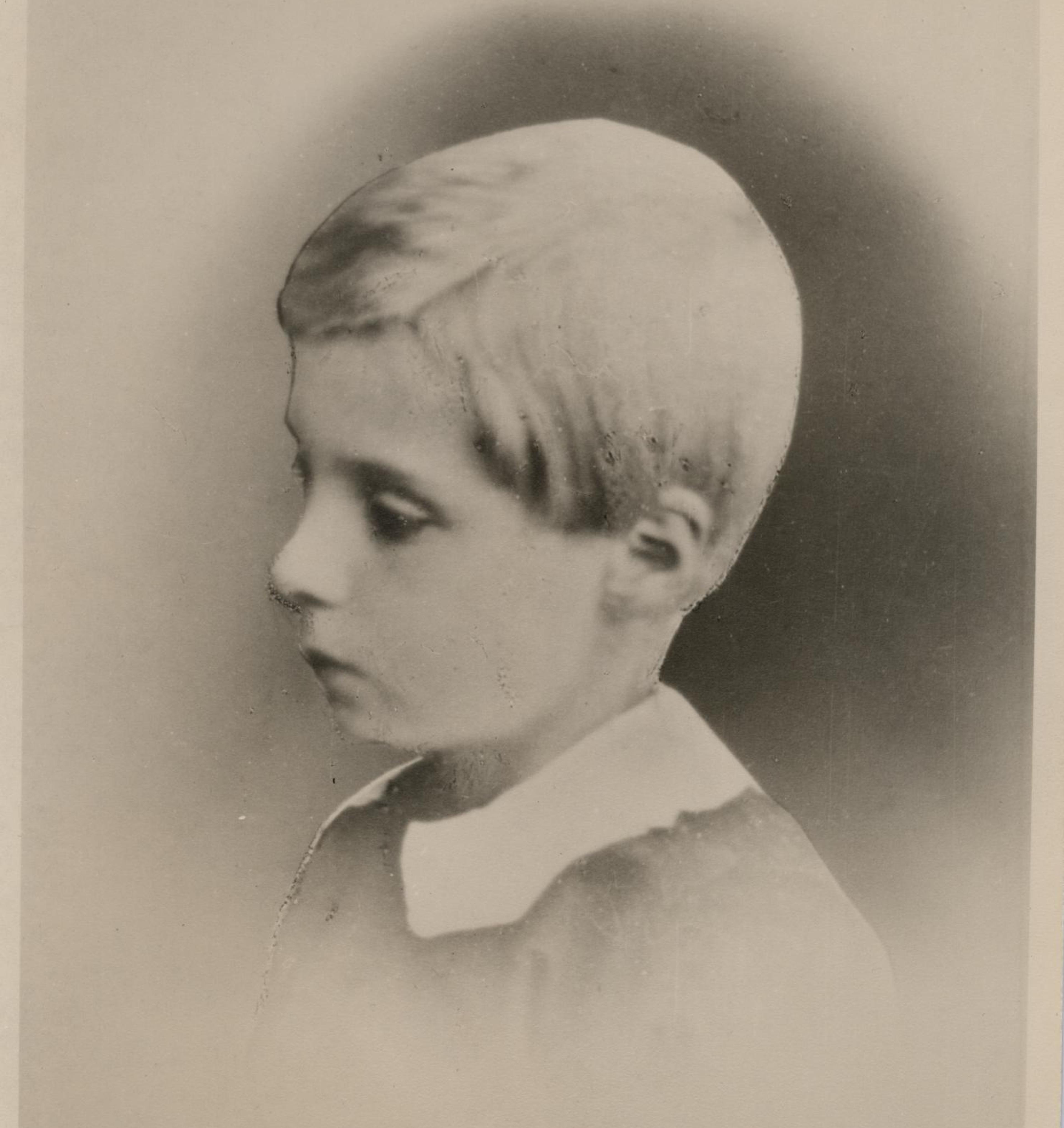 Et eldre fotografi av Edvard Grieg som liten gutt, tatt i profil.