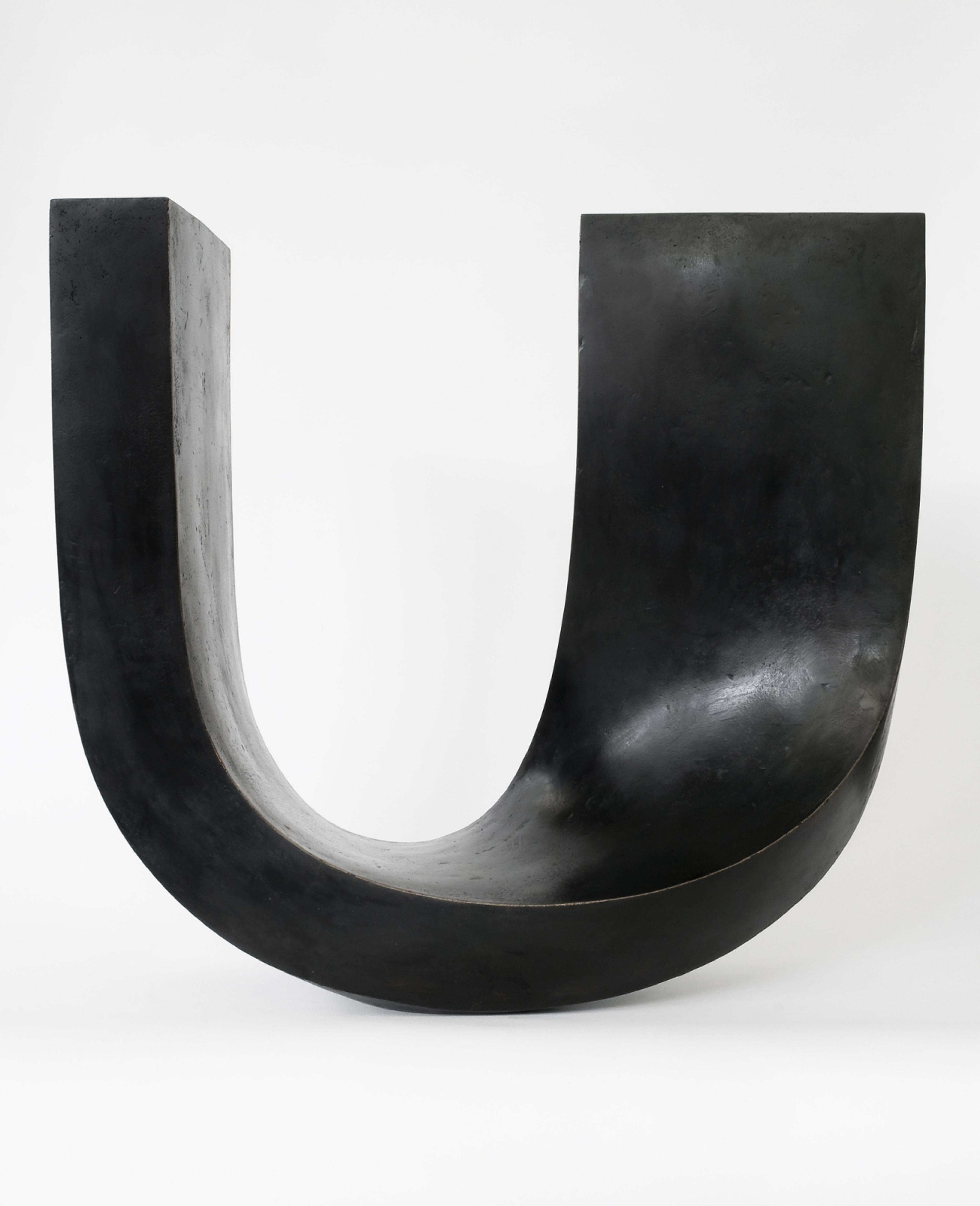 Bilde av skulptur i sort bronse, formet som en u