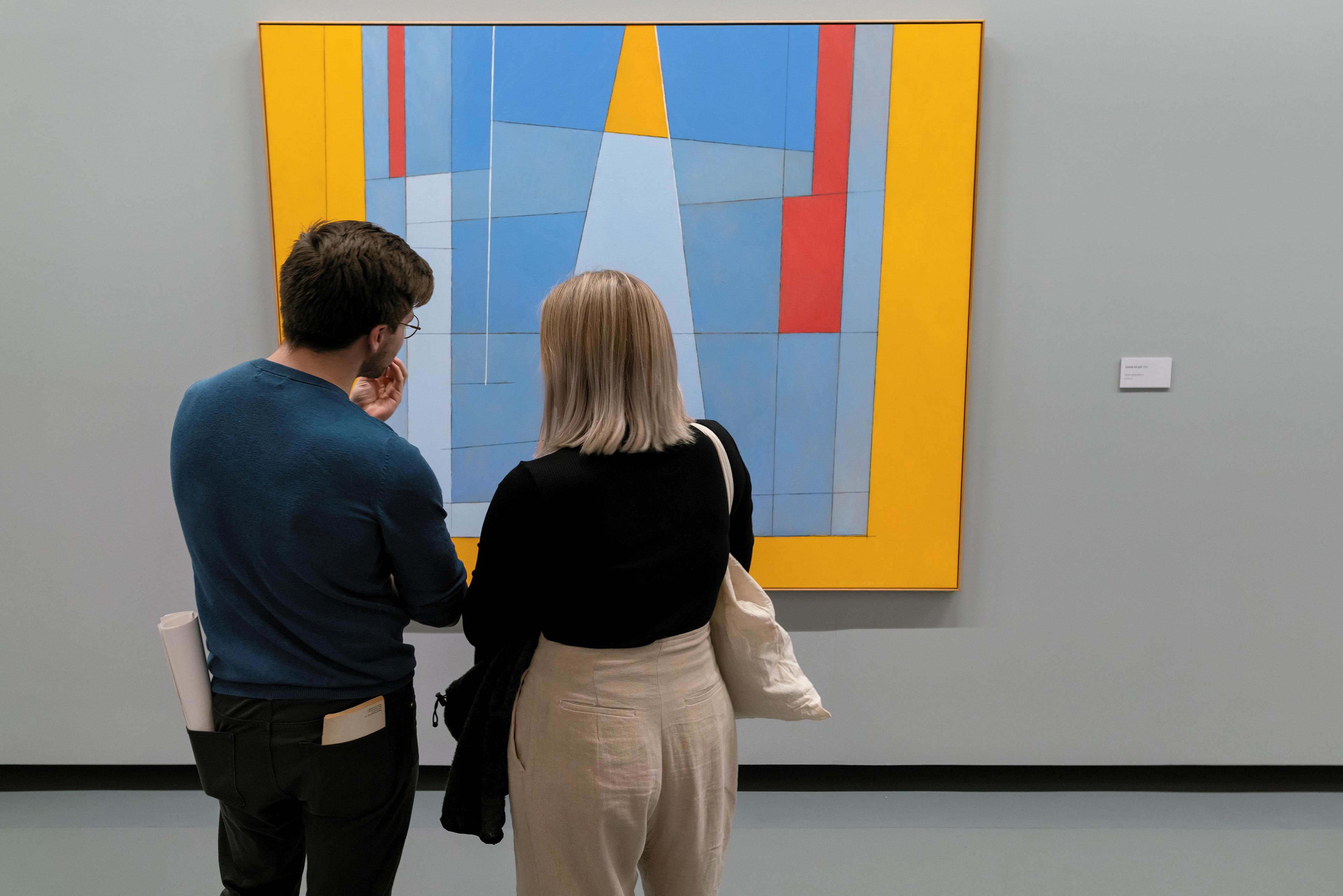 Foto av to personer foran et fargerikt maleri av Irma Salo Jæger.