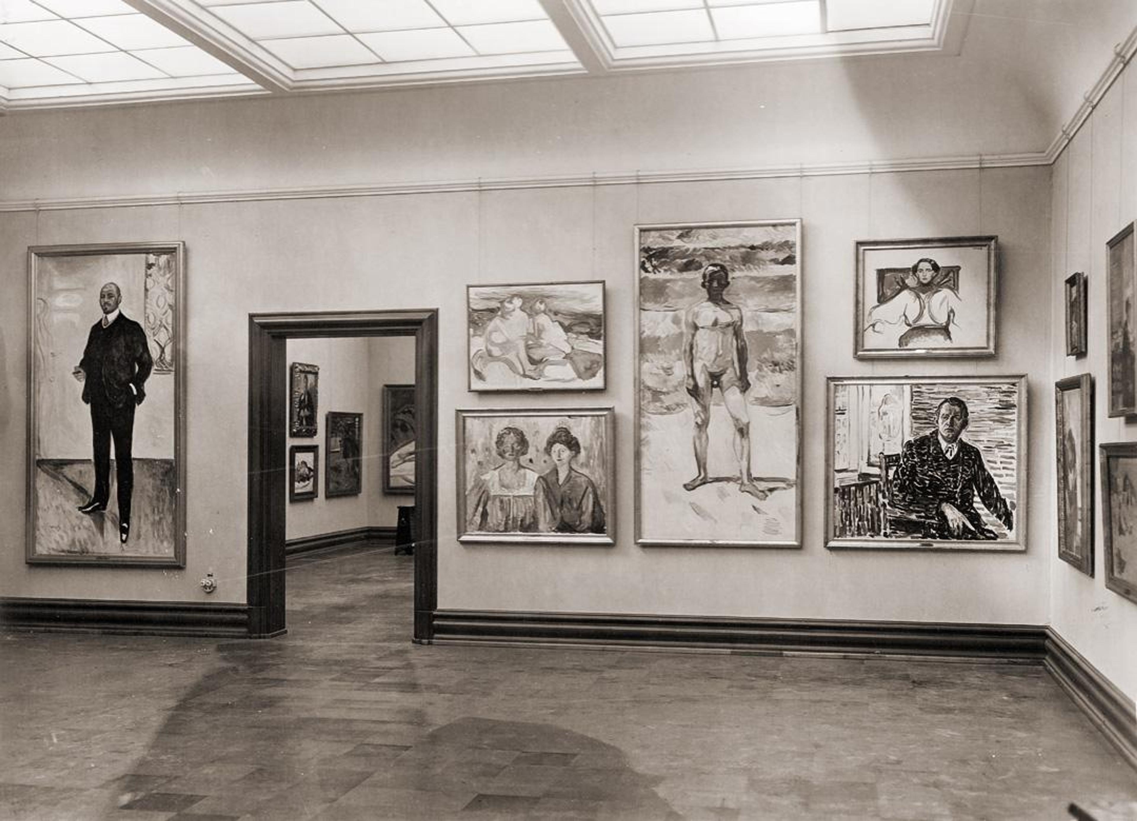 Sort-hvitt fotografi fra Rasmus Meyer, som viser en eldre presentasjon av verk av Edvard Munch.