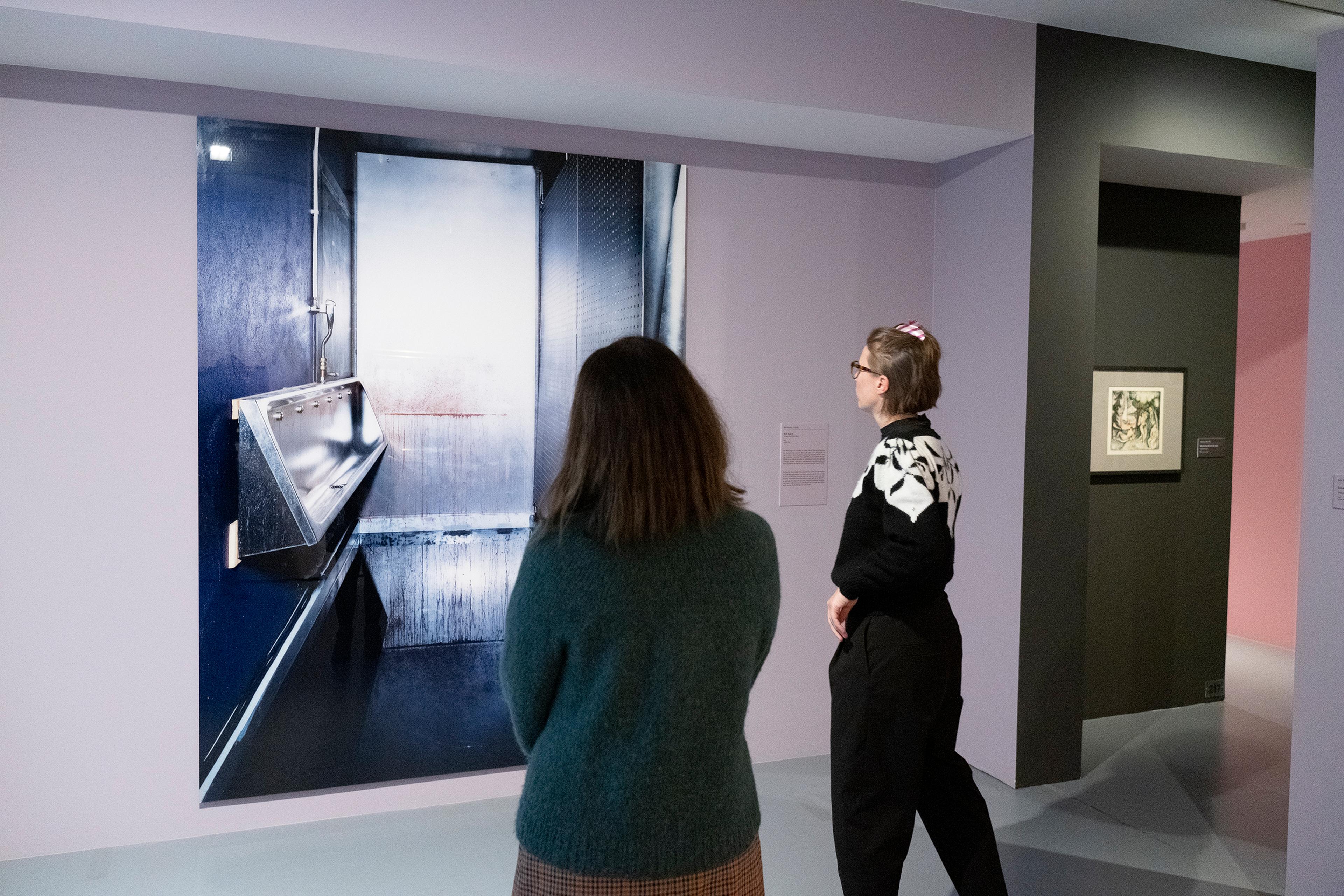 To kvinner ser på et stort fotografi i museet Lysverket