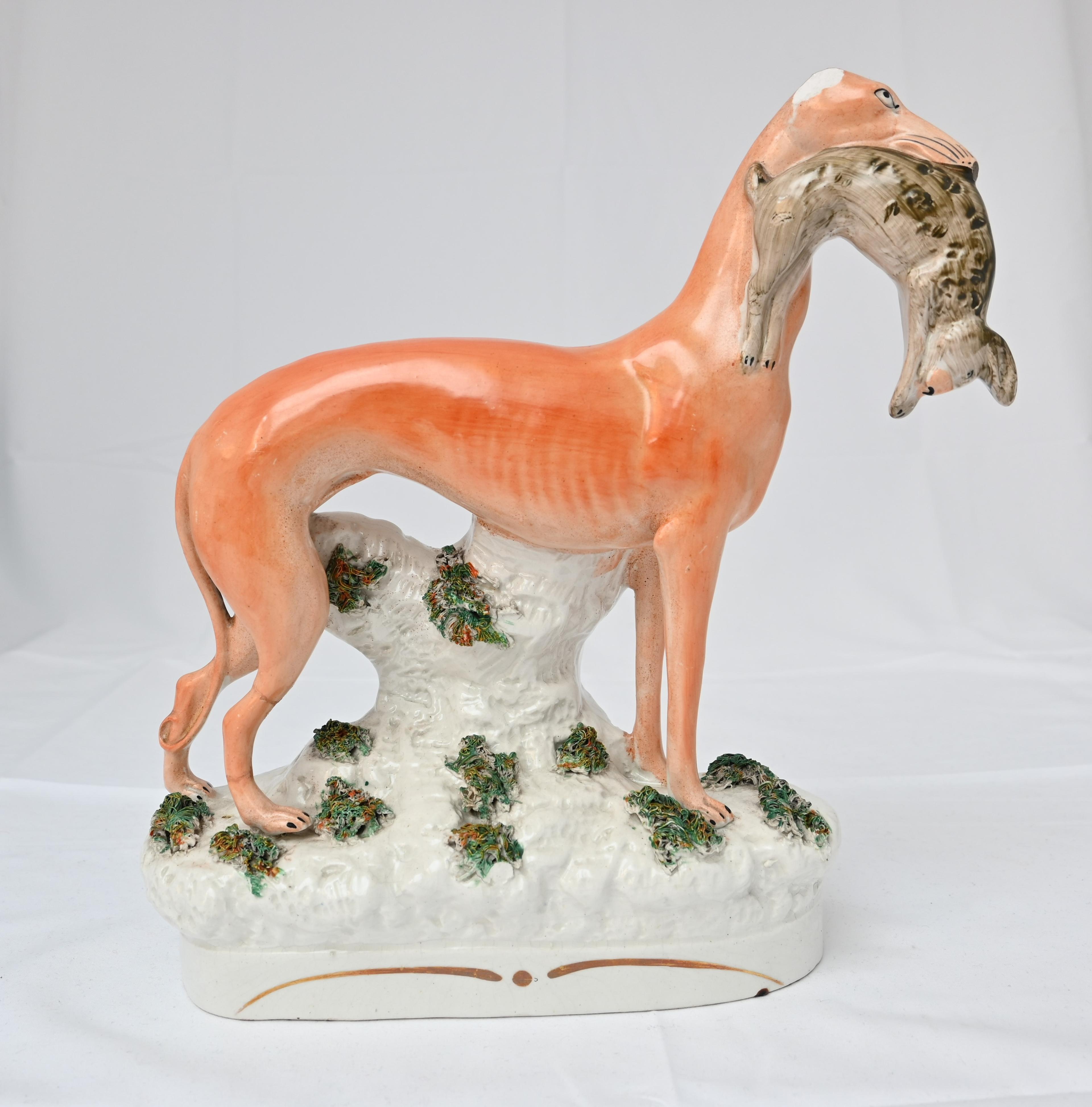 Porselensfigur av en hund med en hare i kjeften