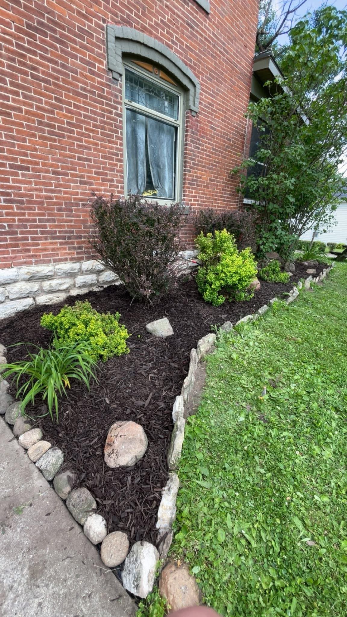 Finished stone-edged landscape bed