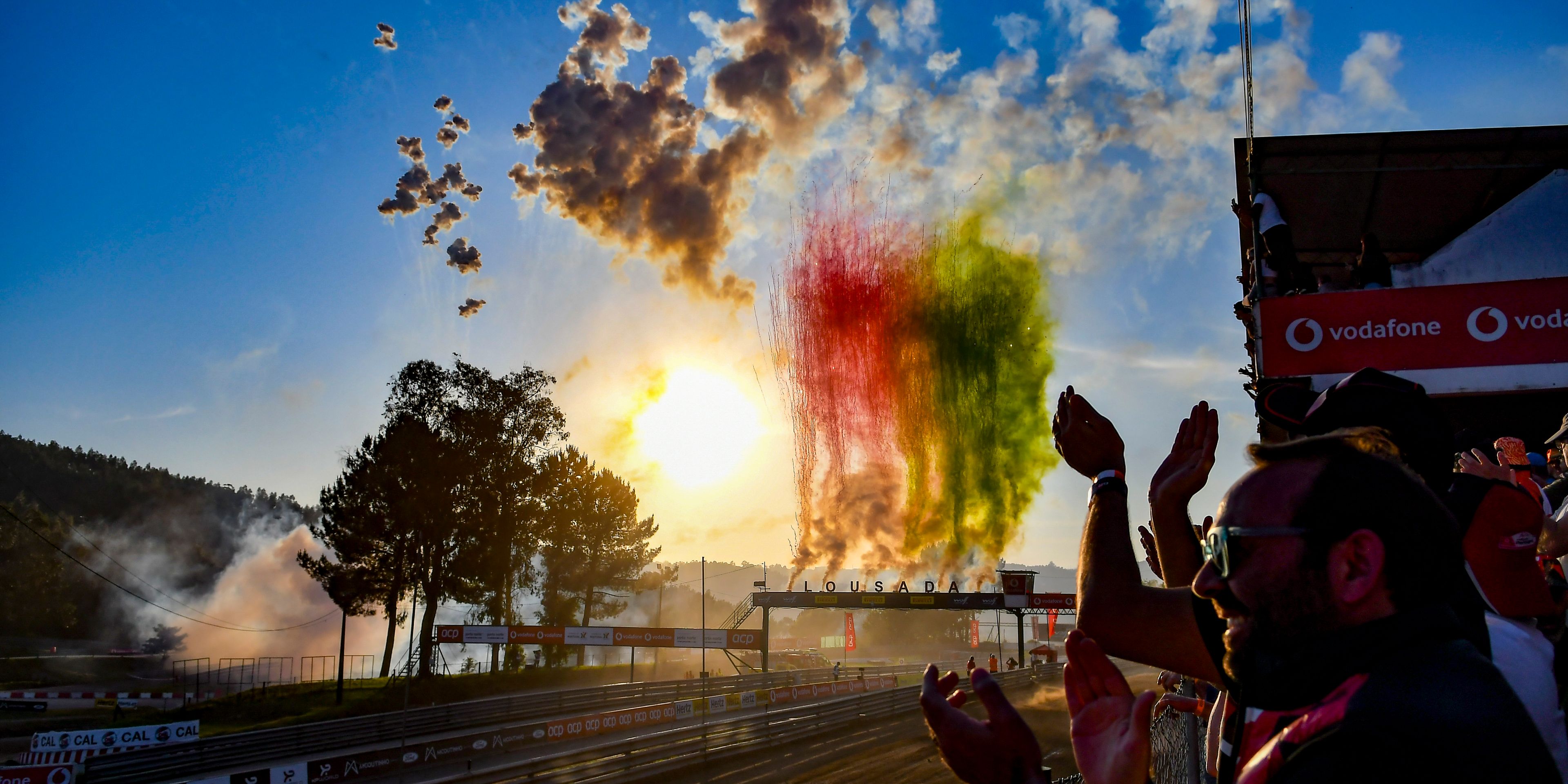 a group of people are watching a fireworks display at a race track .