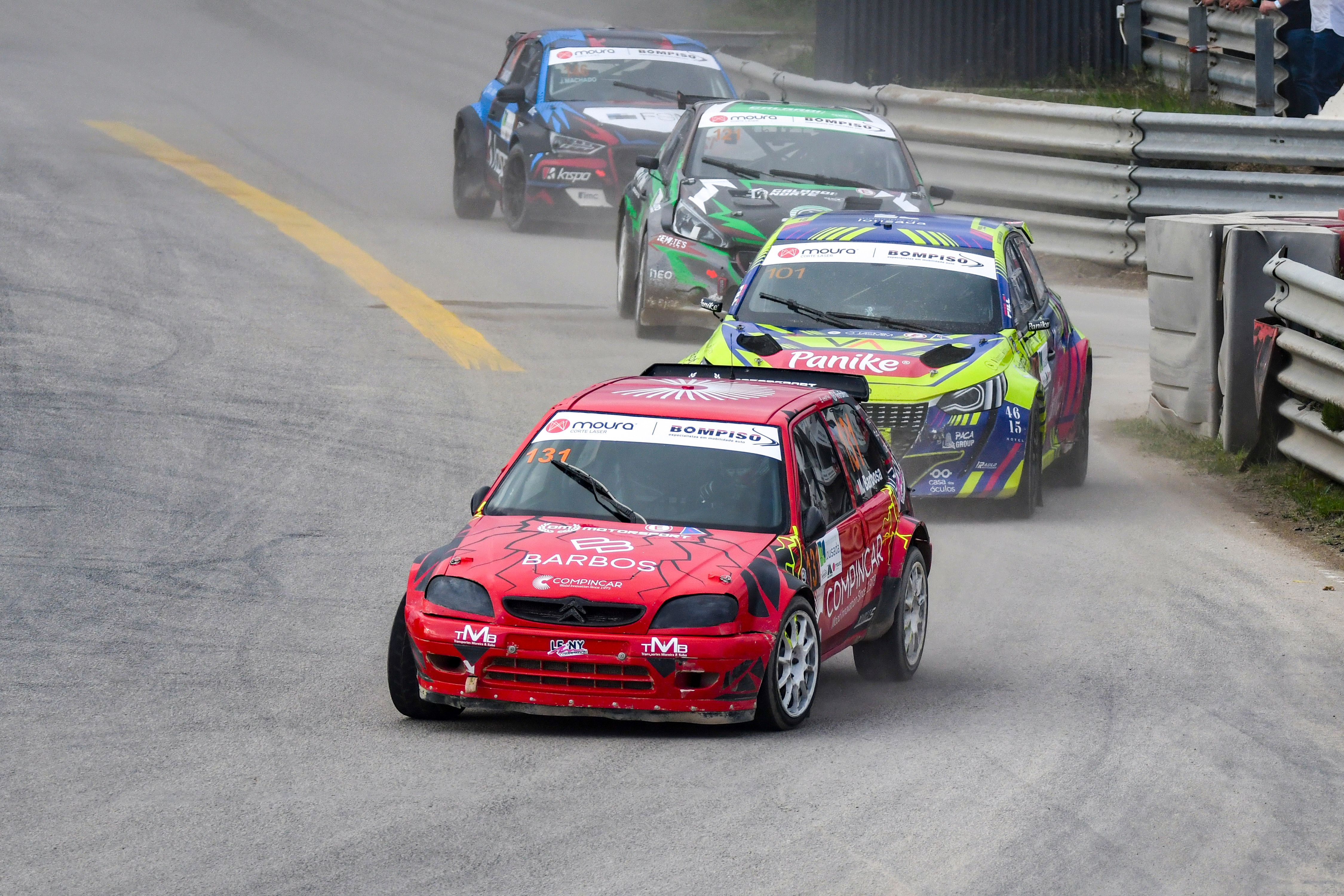 a group of racing cars are driving down a race track .