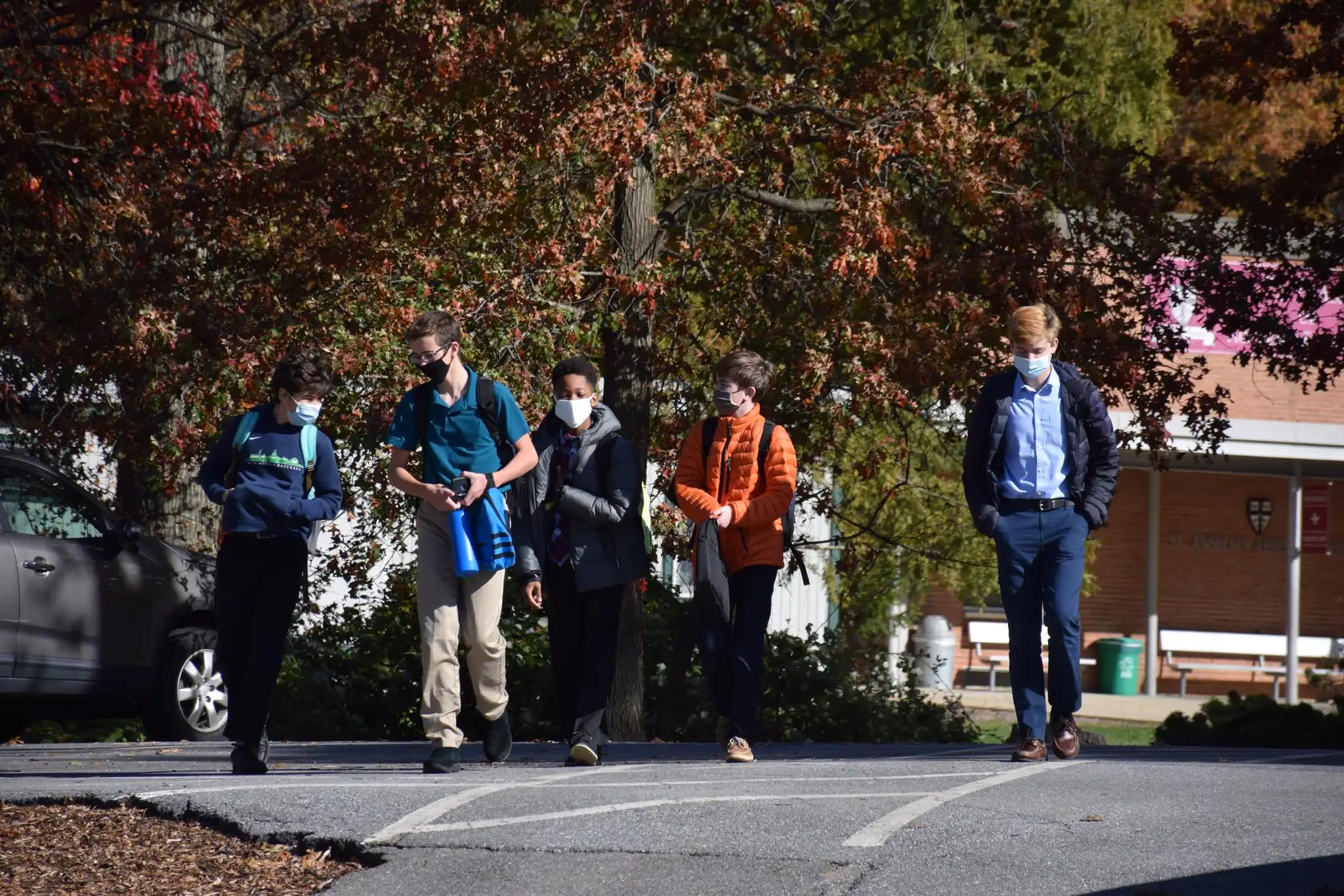 Five students walk outside on the St. Anselm's campus