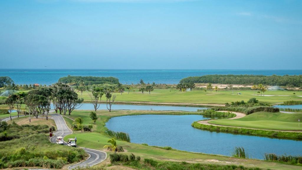 Golf course with lagoons and golf carts overlooking the Caribbean Sea on Roatán, Honduras