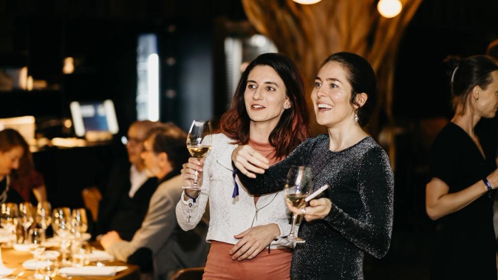 Layla Blake and Nicole Reese raising wine glasses at the VIP dinner at Restaurant Mlýnec in Prague