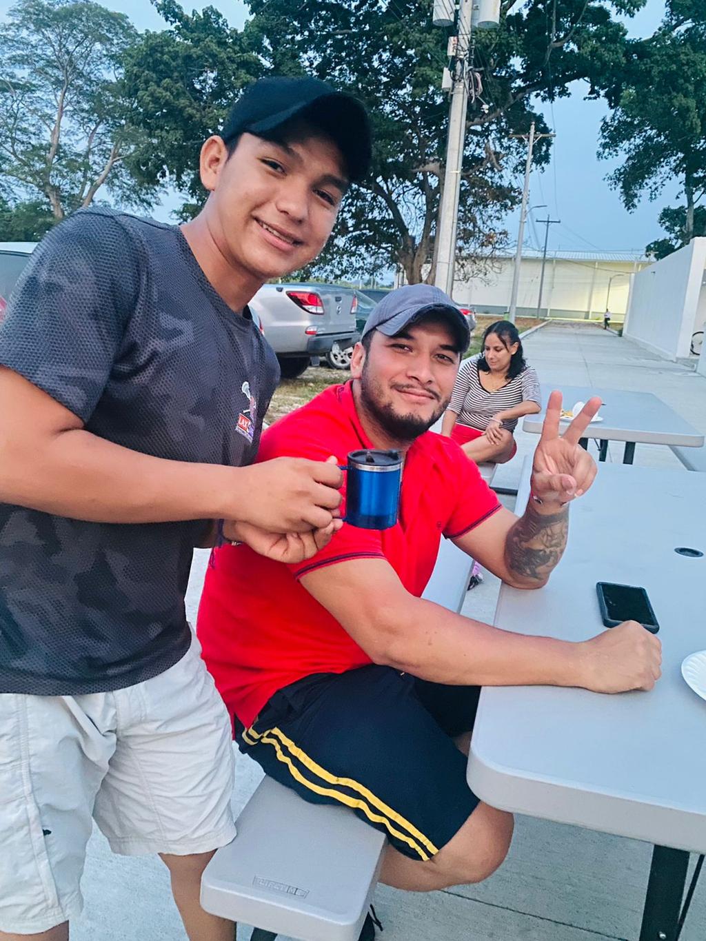 Anthoni giving a prize mug to Angel at a picnic table in Ciudad Morazán, Honduras