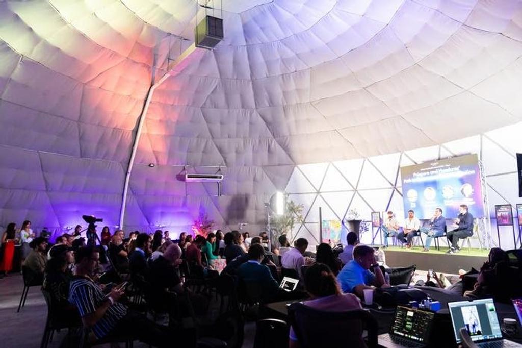 Audience inside a dome tent watching a panel at Infinita's Liberty Acceleration Summit in Próspera, Honduras