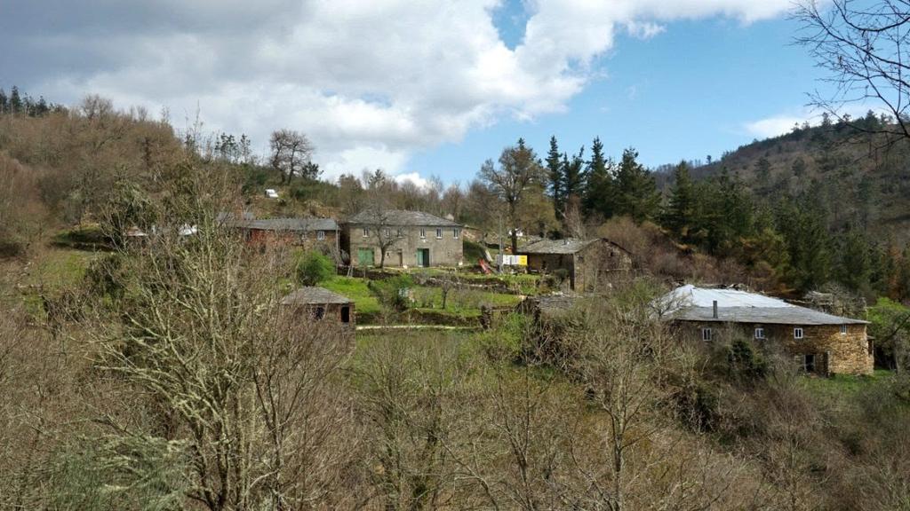 Stone houses on a wooded hillside in the abandoned Spanish village Free Commune plans to revitalise