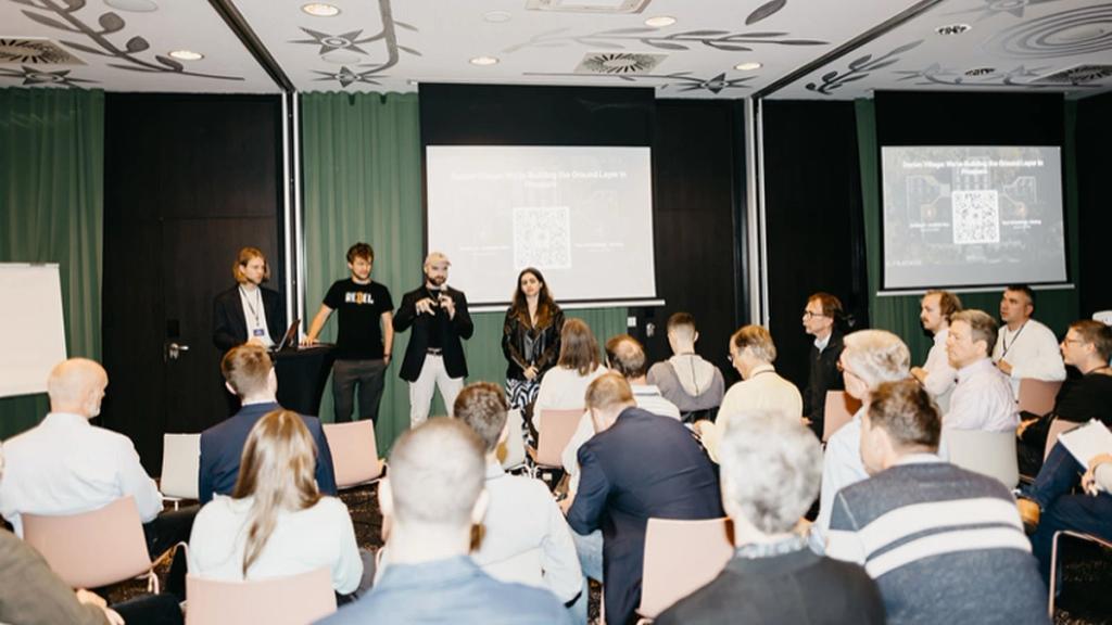 Panel of speakers addressing a seated audience in a closed-door breakout session at the Free Cities Conference