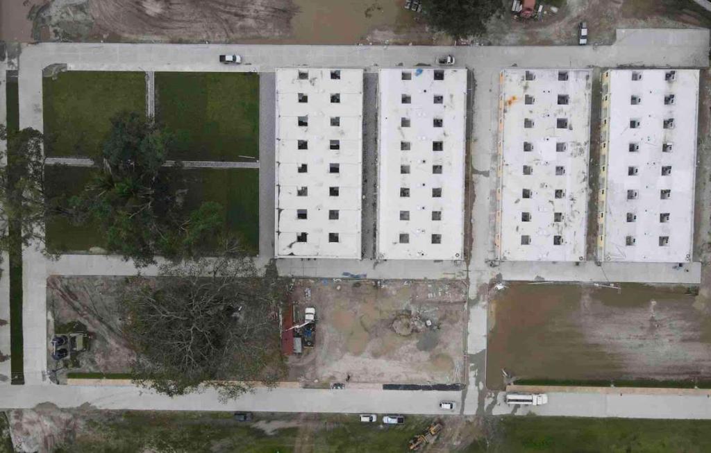 Aerial view of the first 64 houses in Ciudad Morazán, rows of white roofed blocks beside empty lots