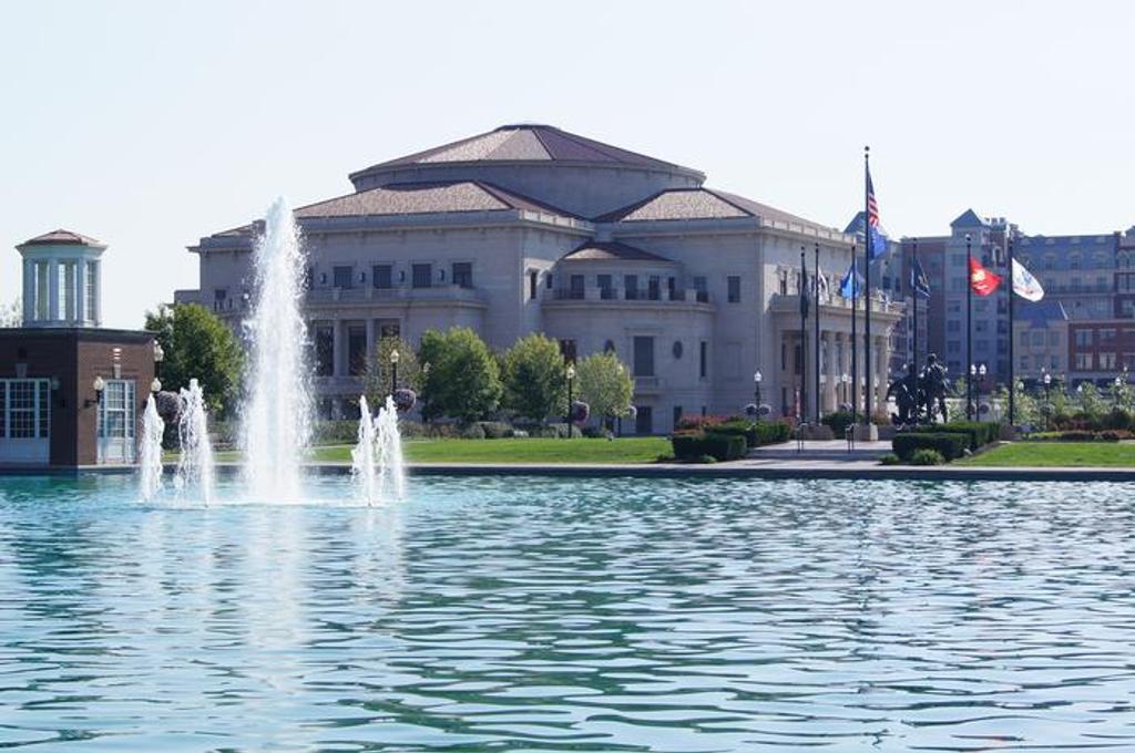 The Palladium concert hall in Carmel, Indiana, seen across a reflecting pool with fountains and flags