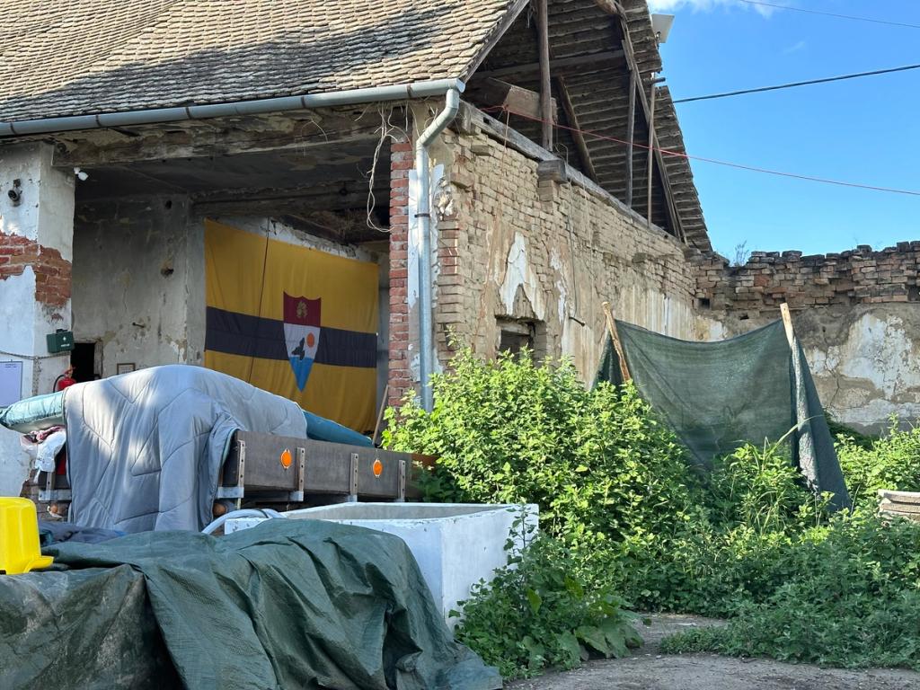 Yellow and black Liberland flag with coat of arms hanging in the old farmhouse of Liberbase in Zmajevac, Croatia