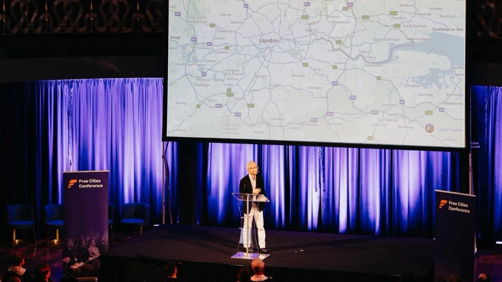 Ivan Ko speaking at Liberty in Our Lifetime 2024 in front of a map of London and the Thames estuary