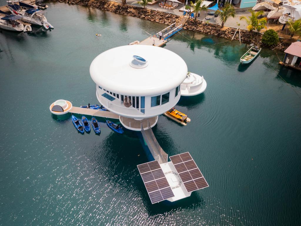 Vista aérea de un prototipo de SeaPod de Ocean Builders en Panamá, con paneles solares y kayaks junto al muelle