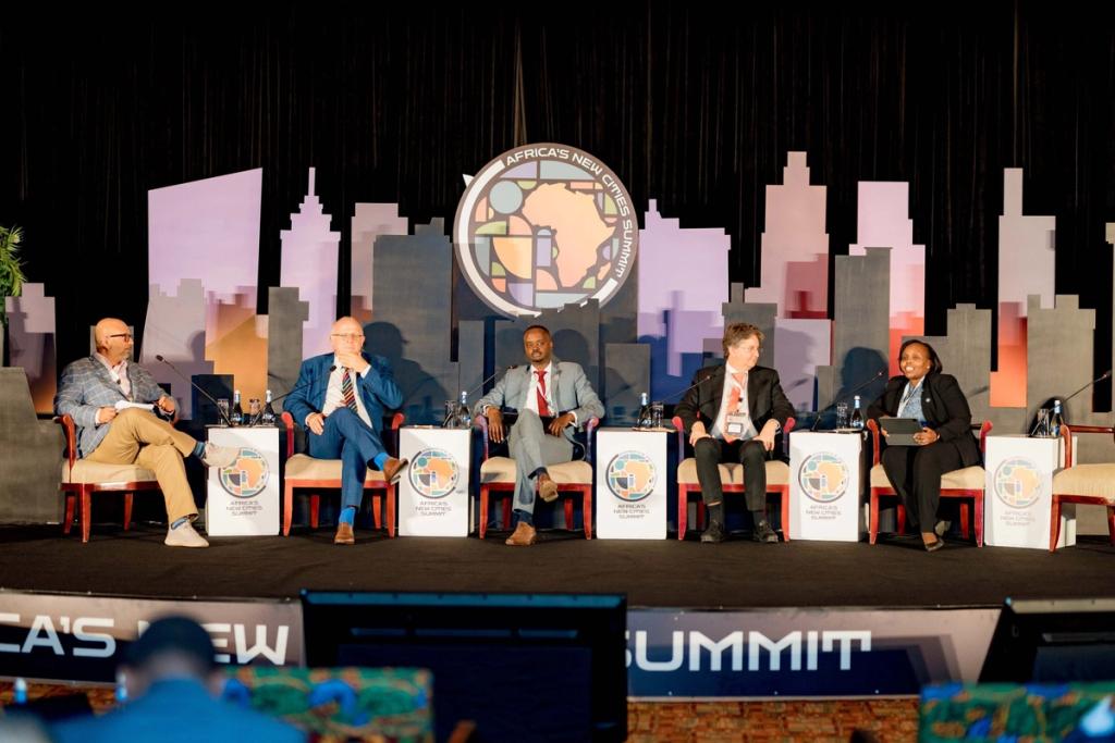 Five panelists including Tipolis CSO Andreas Baumgartner on stage at Africa's New Cities Summit discussing investing in new cities