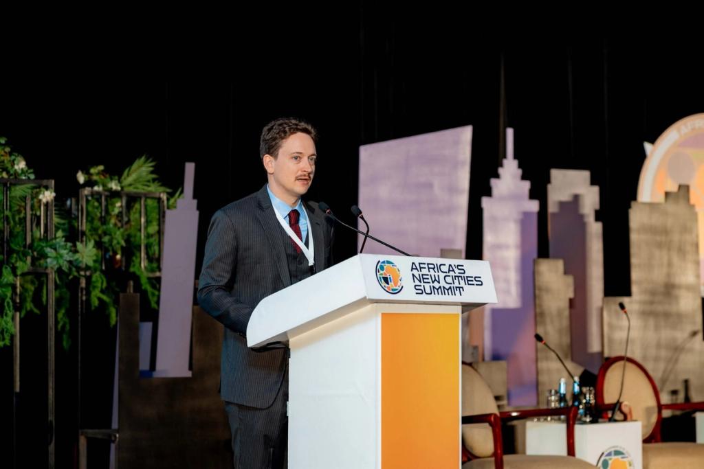 Charter Cities Institute founder Mark Lutter speaking at a lectern at Africa's New Cities Summit