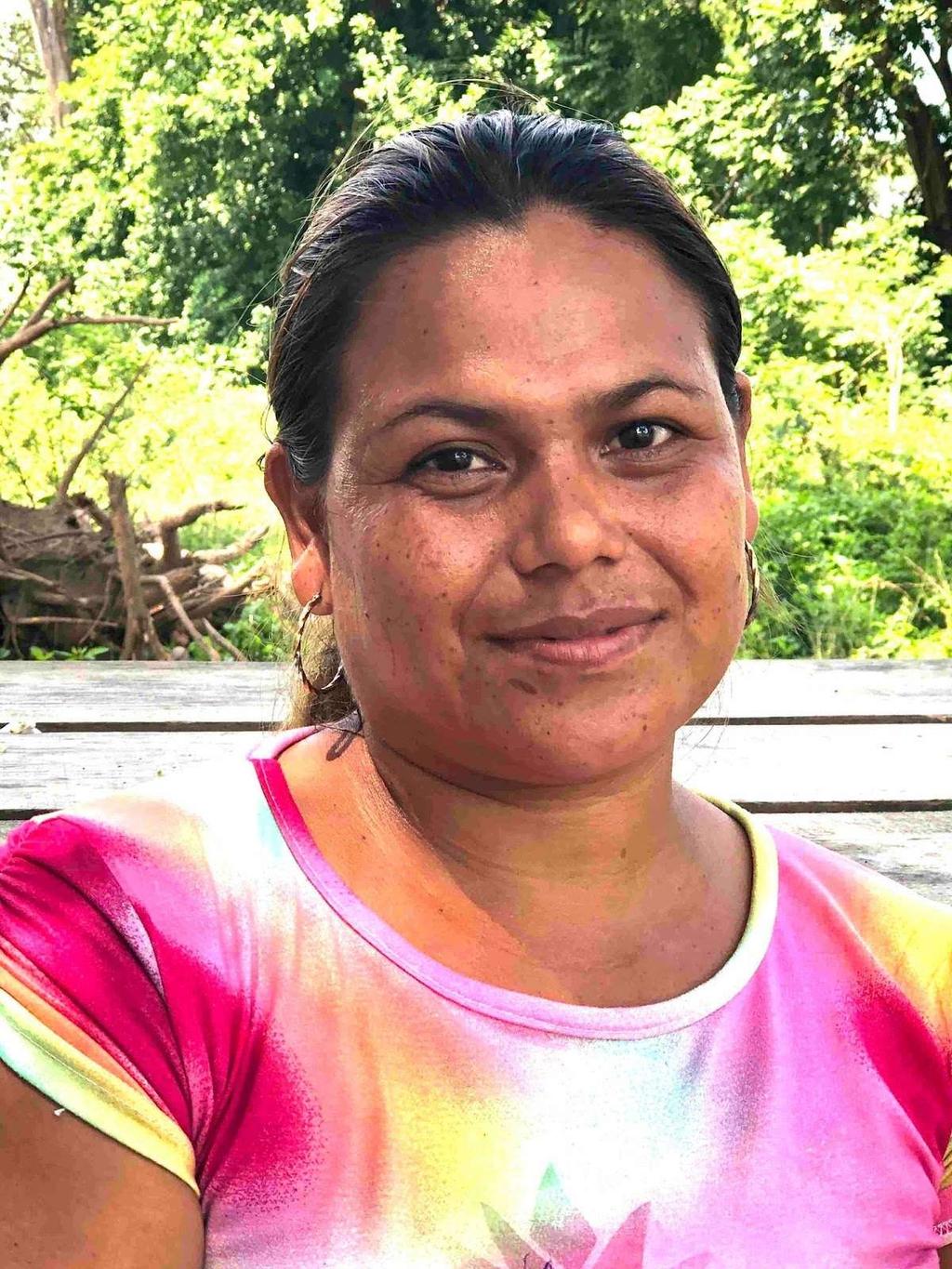 Portrait of Rosa Amanda Aguilar, the first commercial resident of Ciudad Morazán, in a colourful shirt