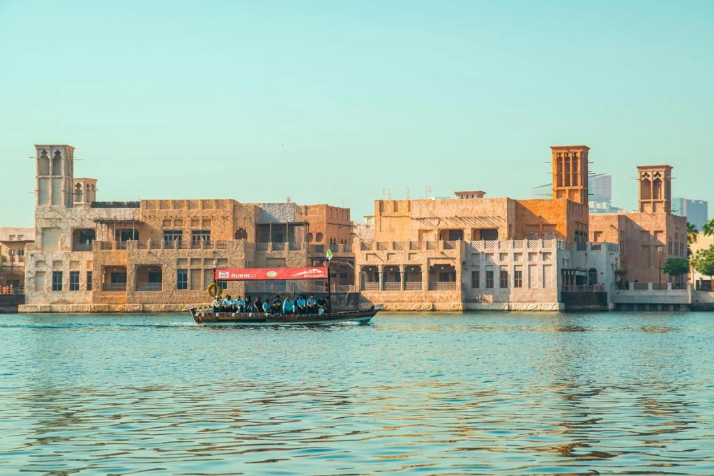 Abra boat on Dubai Creek passing the wind-tower houses of Al Bastakiya, Dubai's historic district