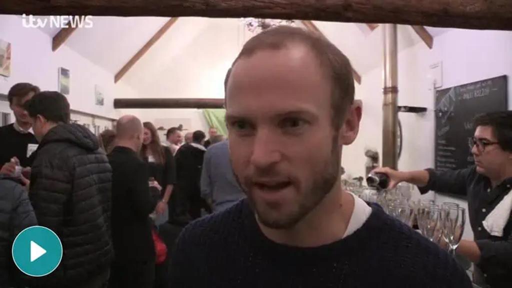ITV News interview with a new Sark resident at a crowded welcome gathering in a beamed hall