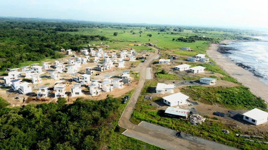 Aerial view of new white off-grid homes under construction beside the beach at Gran Pacifica, Nicaragua