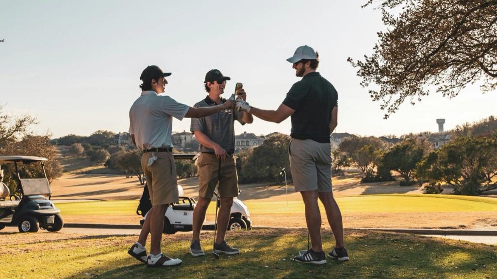 Three golfers toasting on a sunlit fairway, illustrating Roatán's Black Pearl golf course