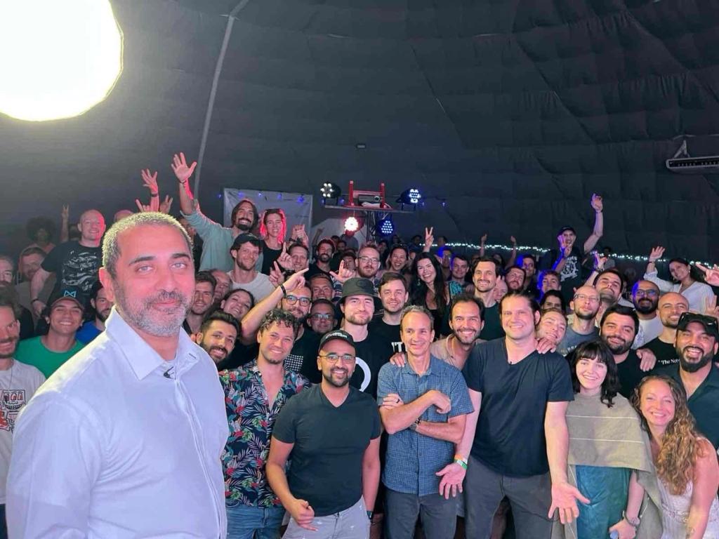 Group photo of cheering attendees inside the Vitalia dome at the Startup Societies and Crypto Cities Summit