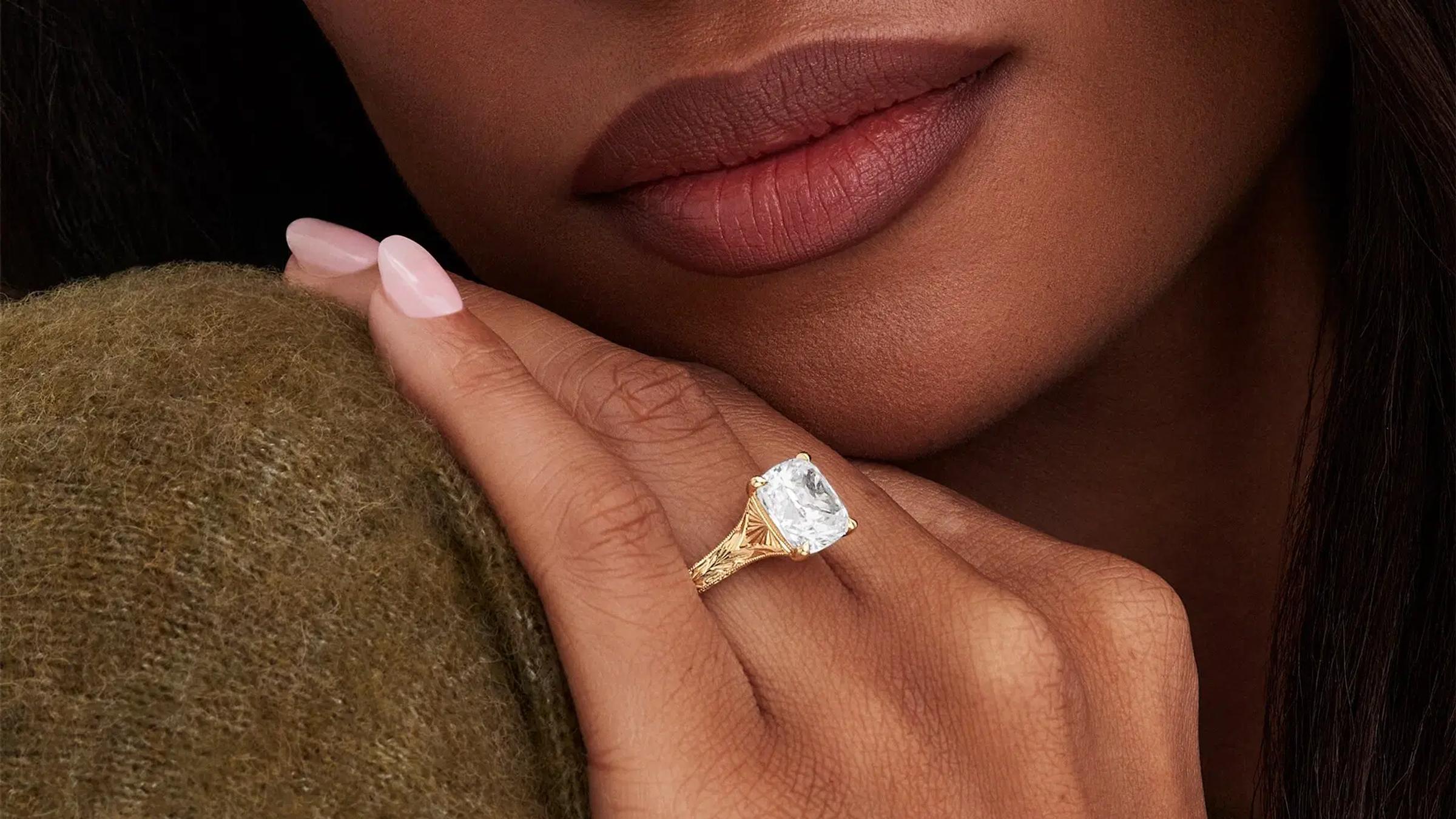 Woman wears hand engraved engagement ring