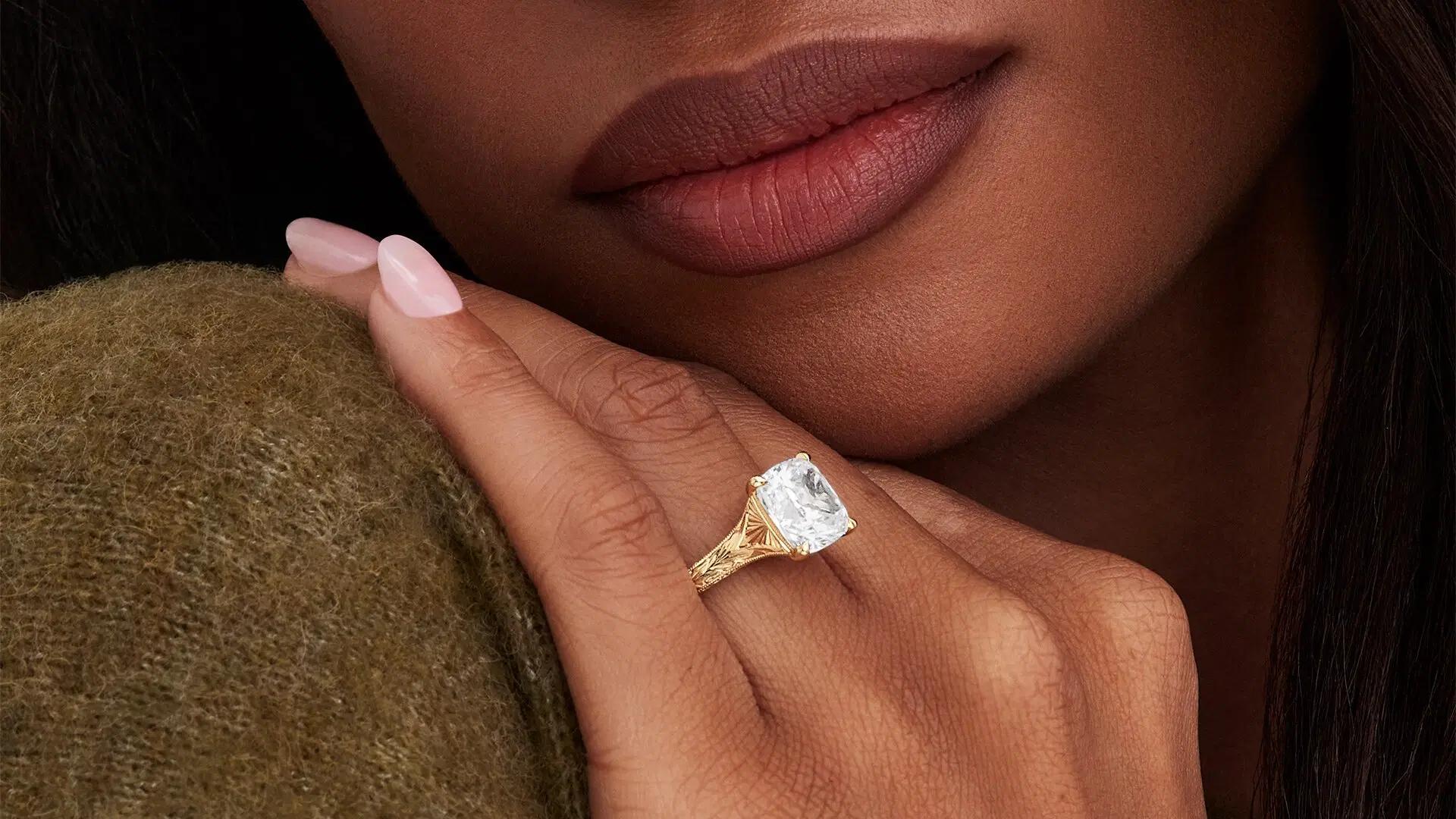 Woman wears hand engraved engagement ring