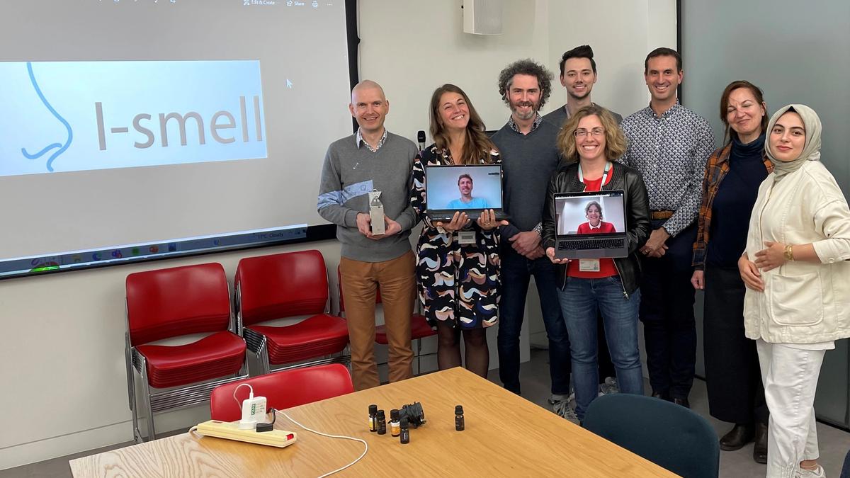 Group of eight people standing in an office