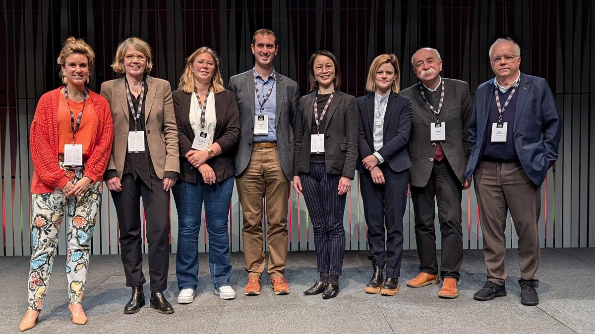 Eight speakers from the symposium standing in a row