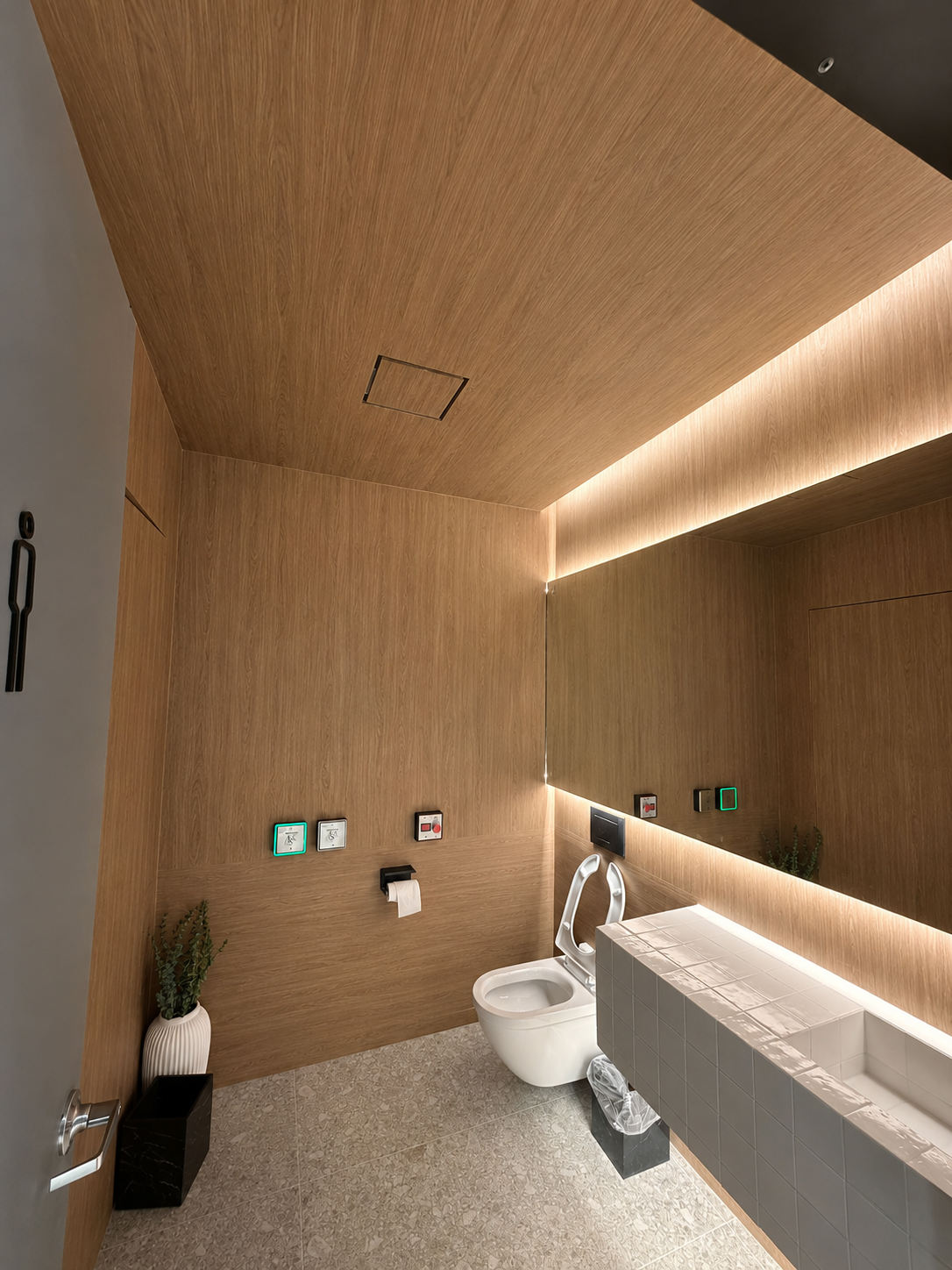 Wood-clad washroom ceiling and wall with integrated lighting