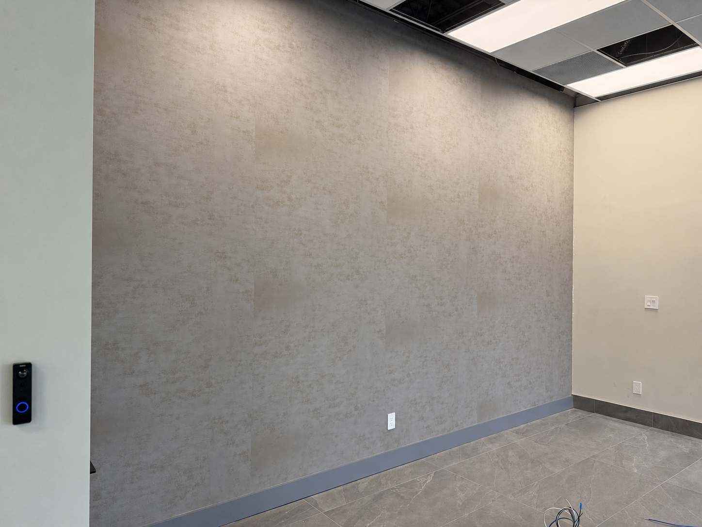 Large commercial feature wall with neutral stone-look architectural film