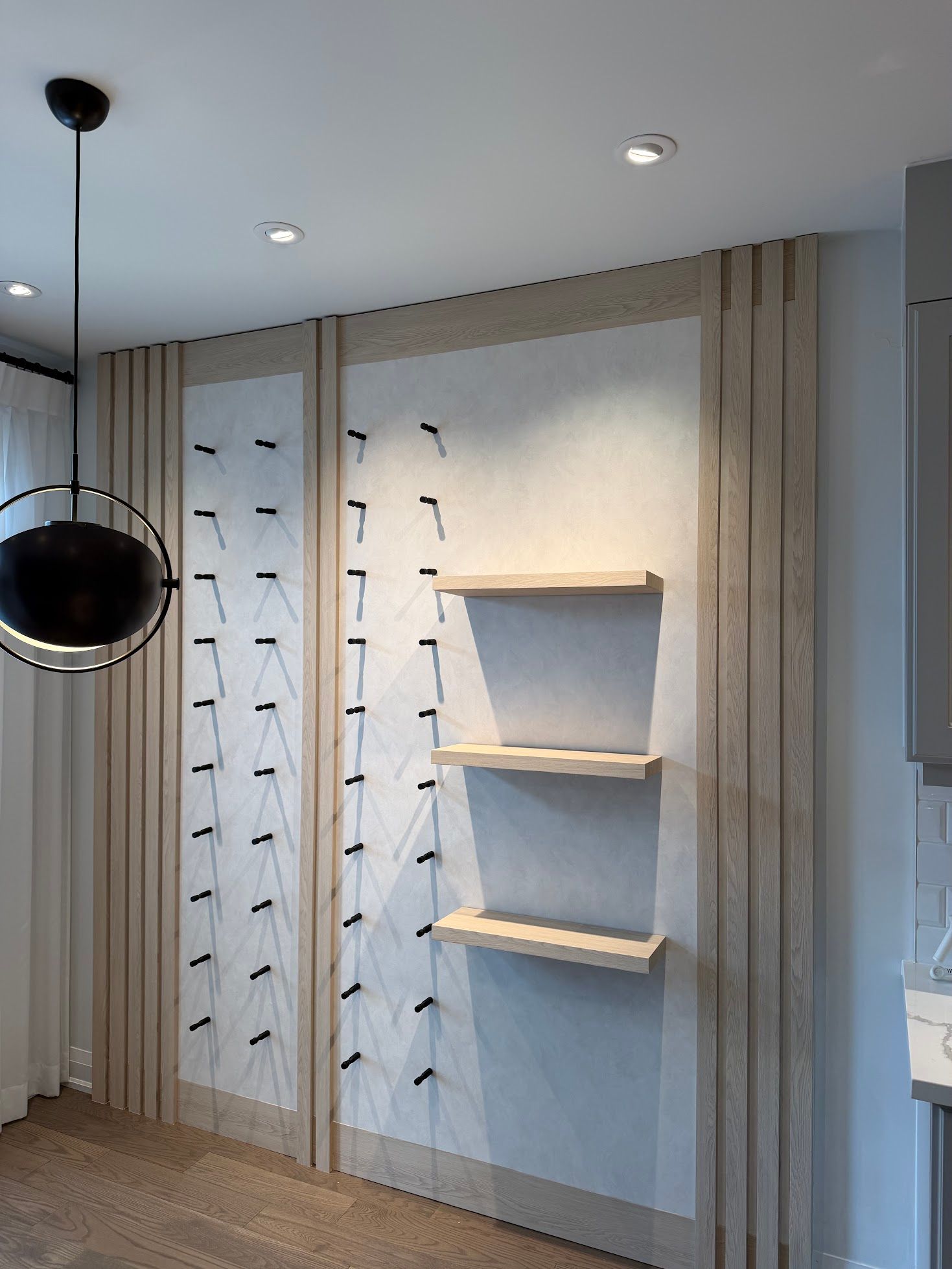 Wood slat feature wall with floating shelves and wine display